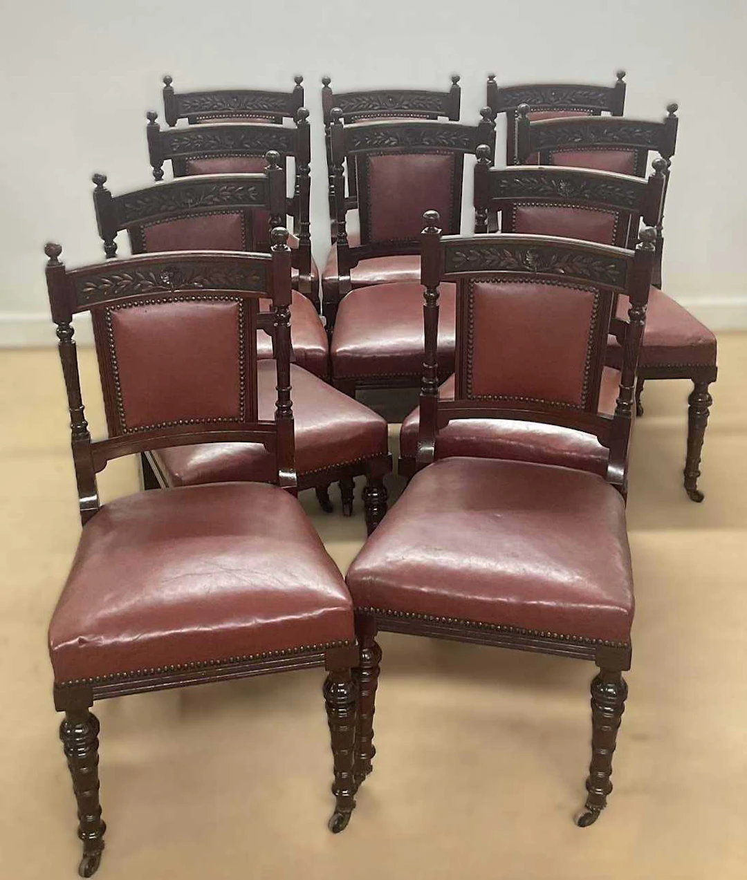 A set of ten mahogany framed dining chairs having red leather seats
