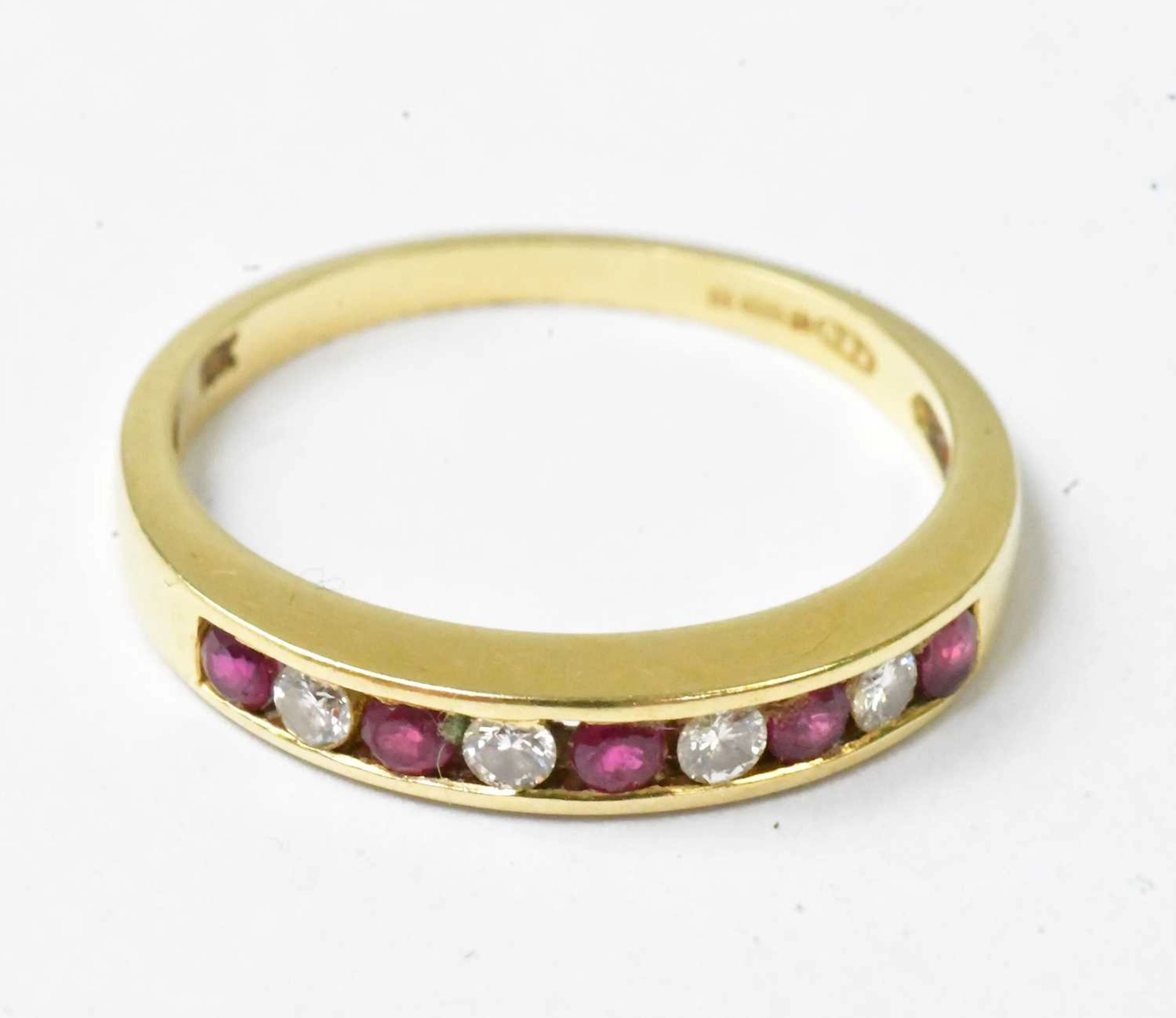 An 18ct yellow gold ring set with four diamonds and five red spinels