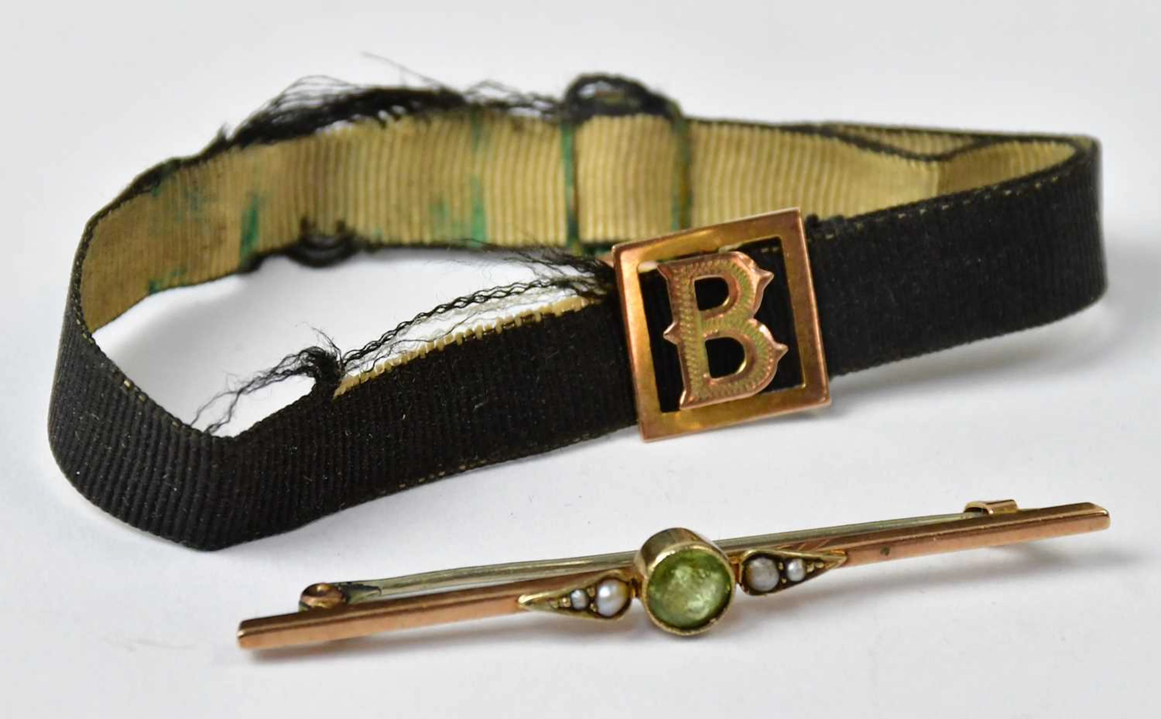 A 9ct yellow gold bar brooch set with a central peridot and seed pearls