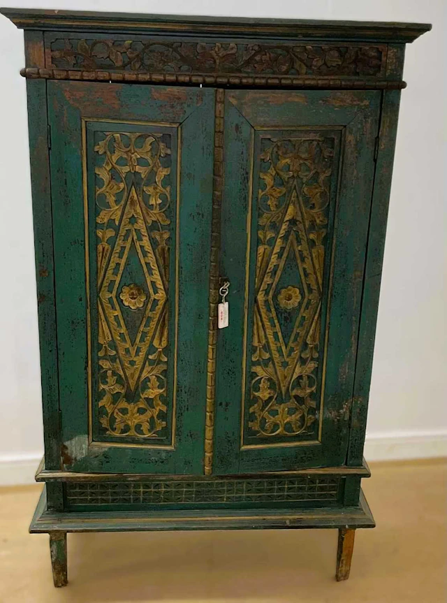 A Indonesian painted twin door cabinet with two fitted shelves
