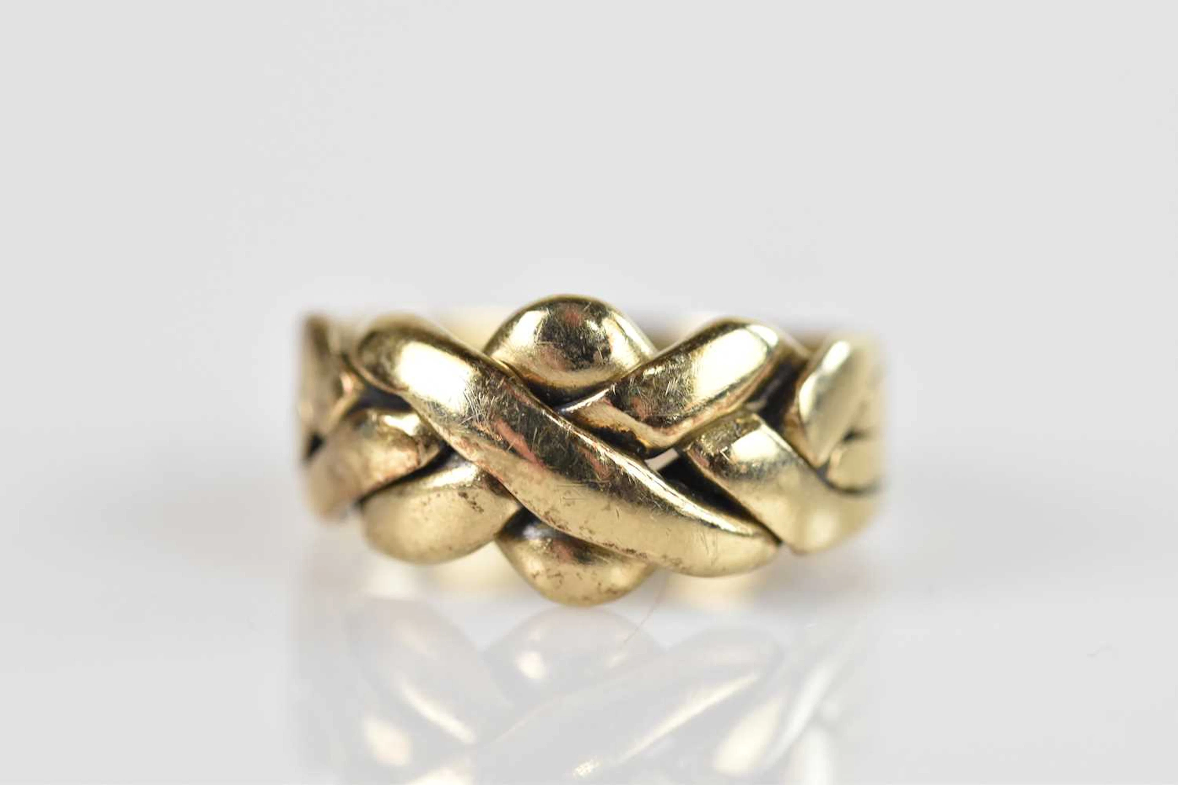 A yellow metal puzzle ring