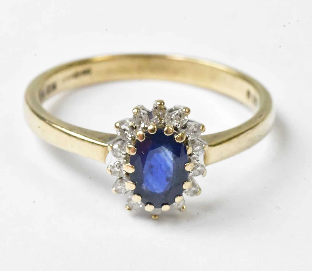 A 9ct yellow gold ring set with a central oval blue stone...
