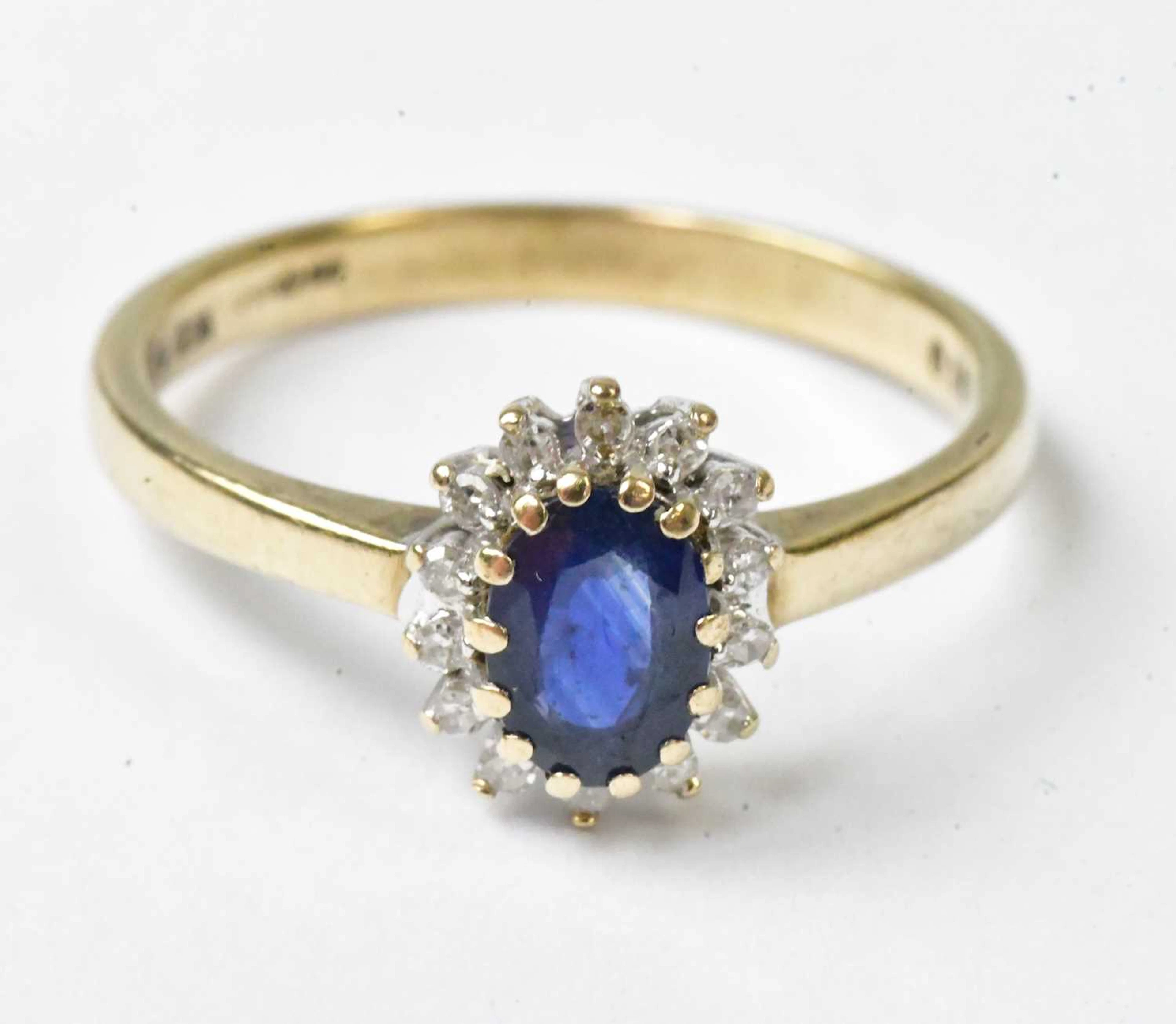 A 9ct yellow gold ring set with a central oval blue stone...
