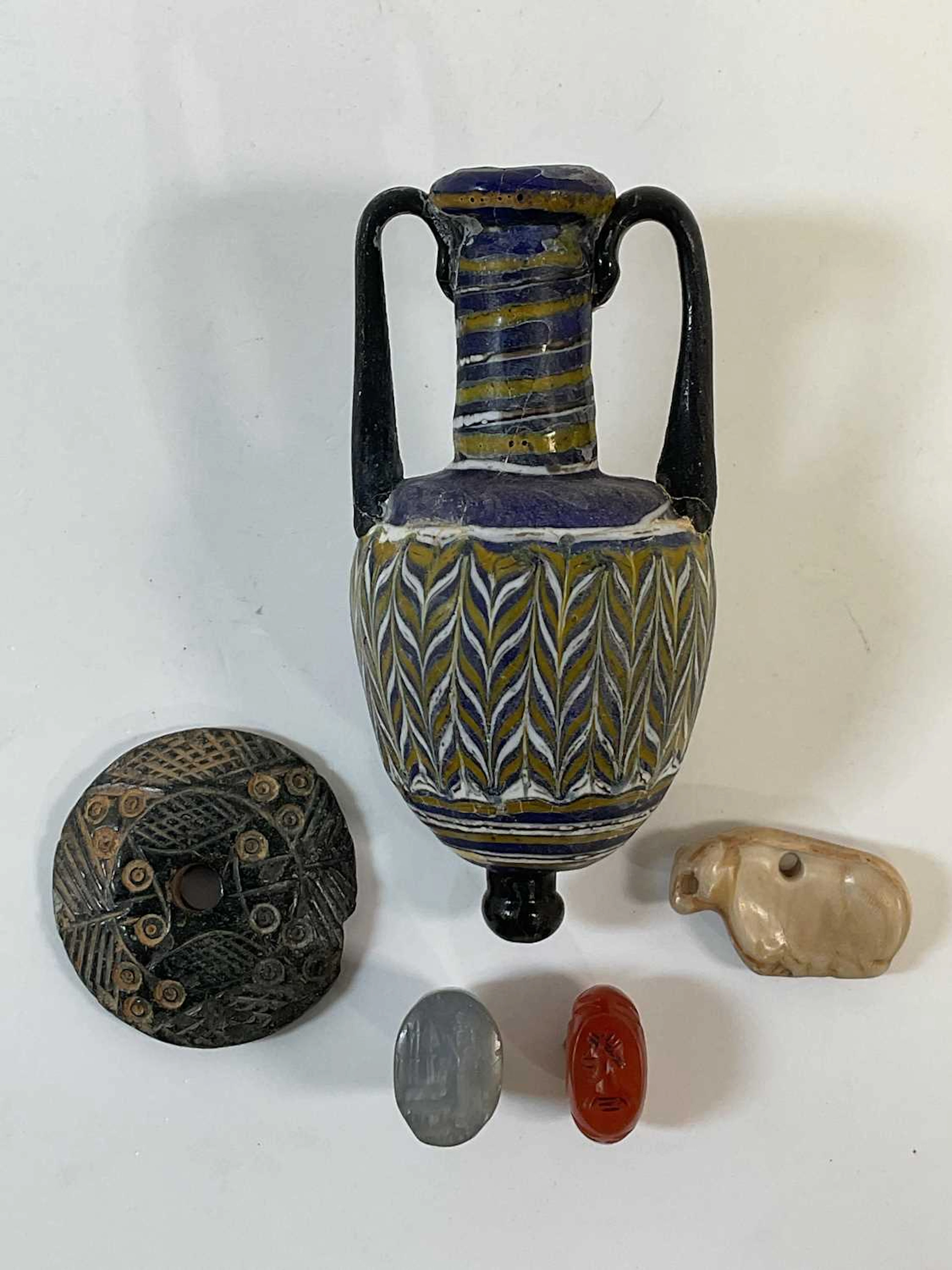An interesting group of five antiquities including a Greek/Roman glass bottle