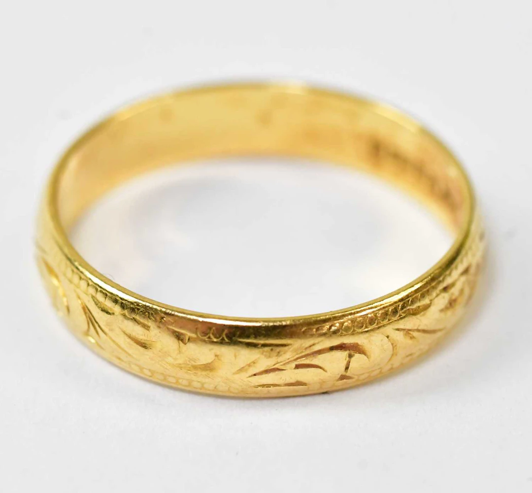 A 22ct yellow gold wedding band with engraved decoration