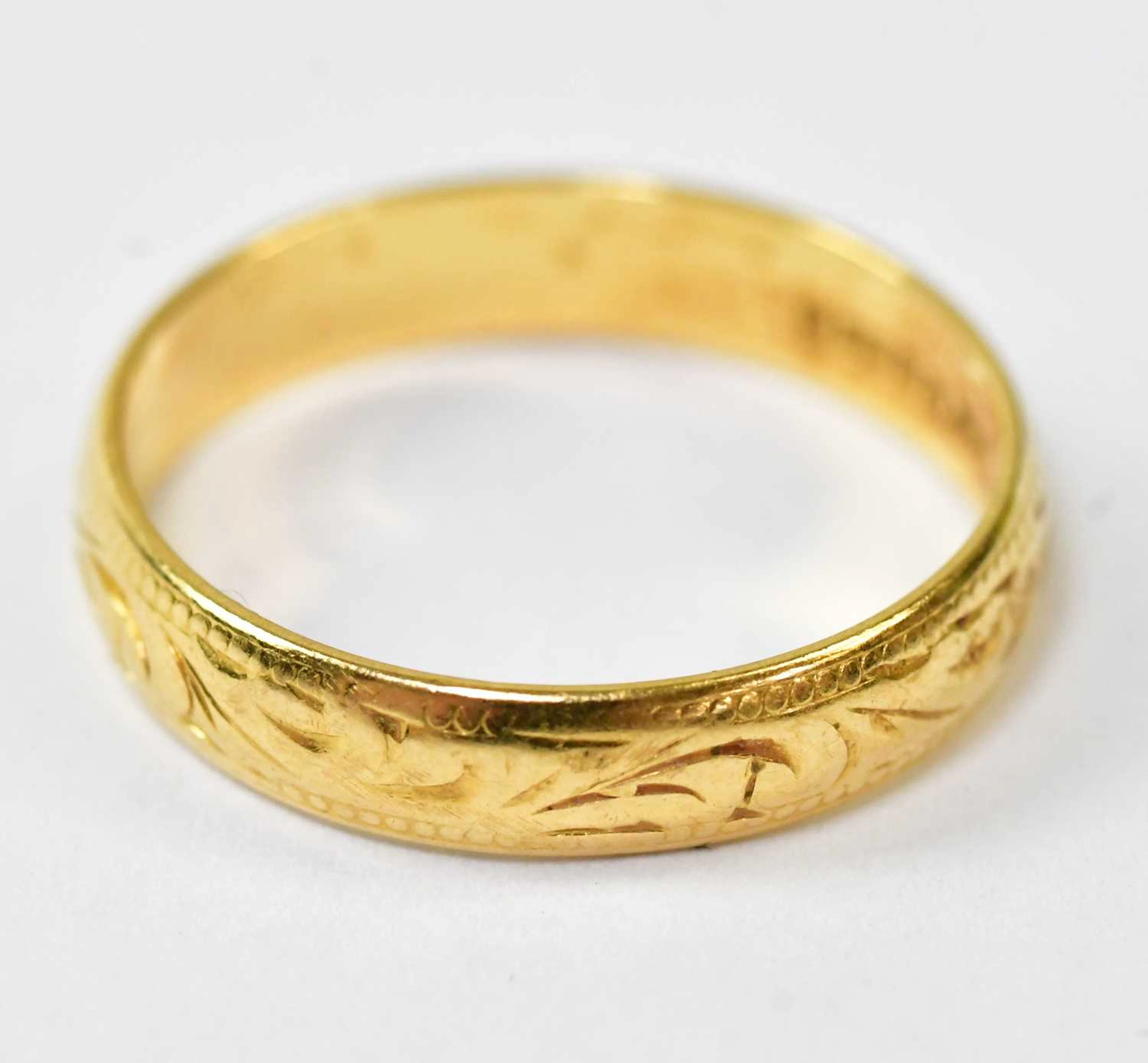 A 22ct yellow gold wedding band with engraved decoration