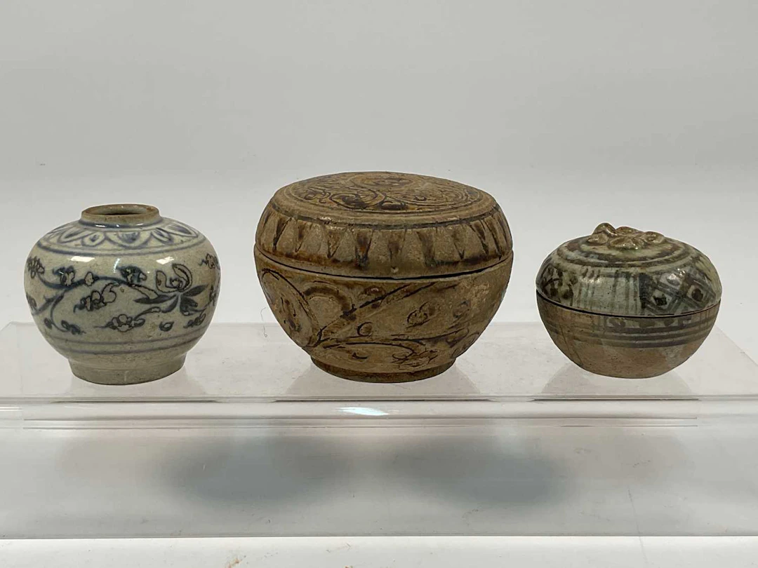 A Thai Sawankhalok covered stoneware pot decorated with scrolling vines