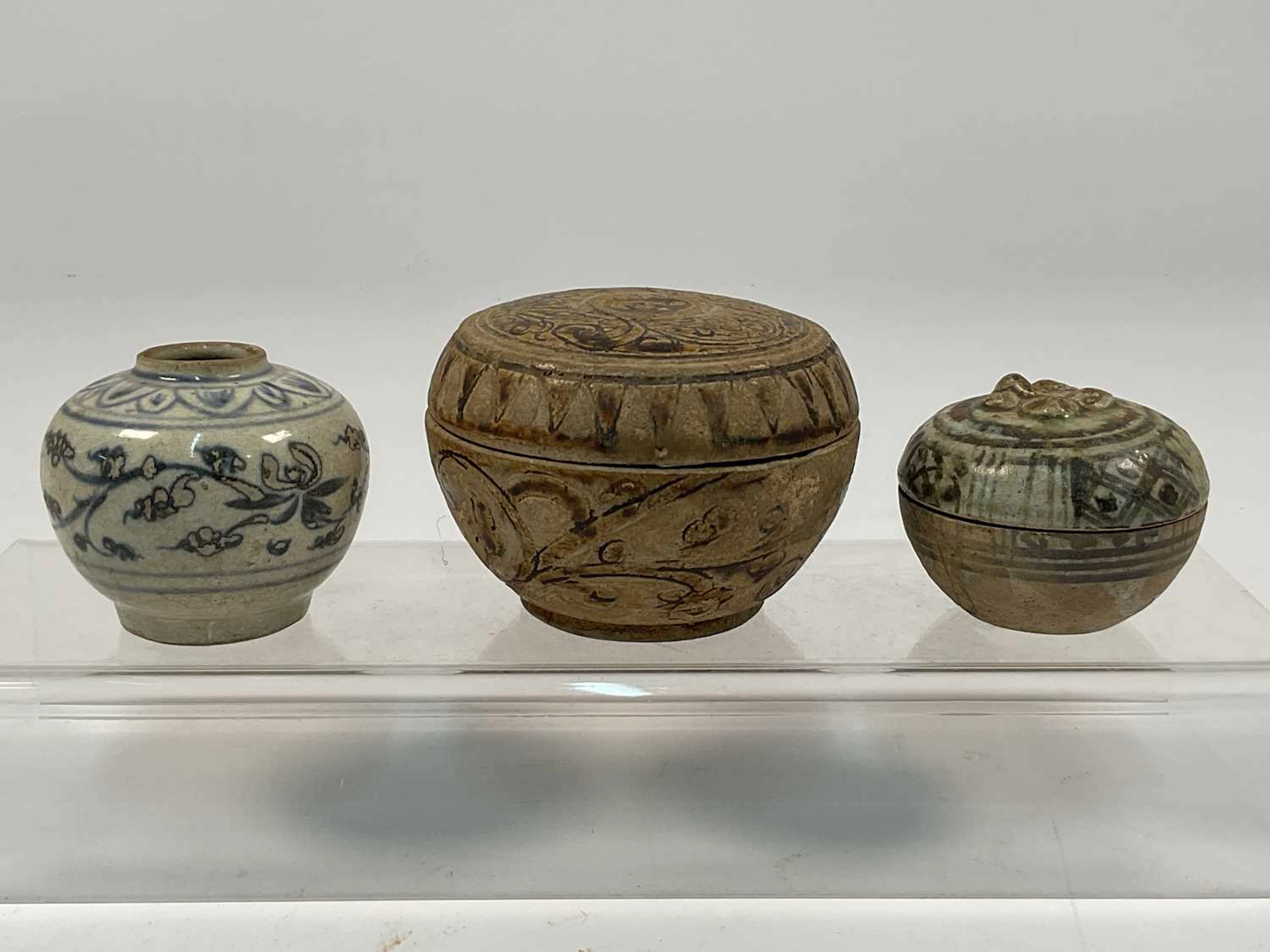 A Thai Sawankhalok covered stoneware pot decorated with scrolling vines