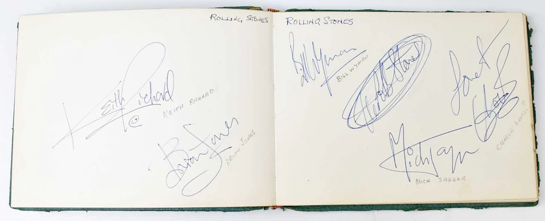 A vintage green autograph book containing a large quantity of autographs