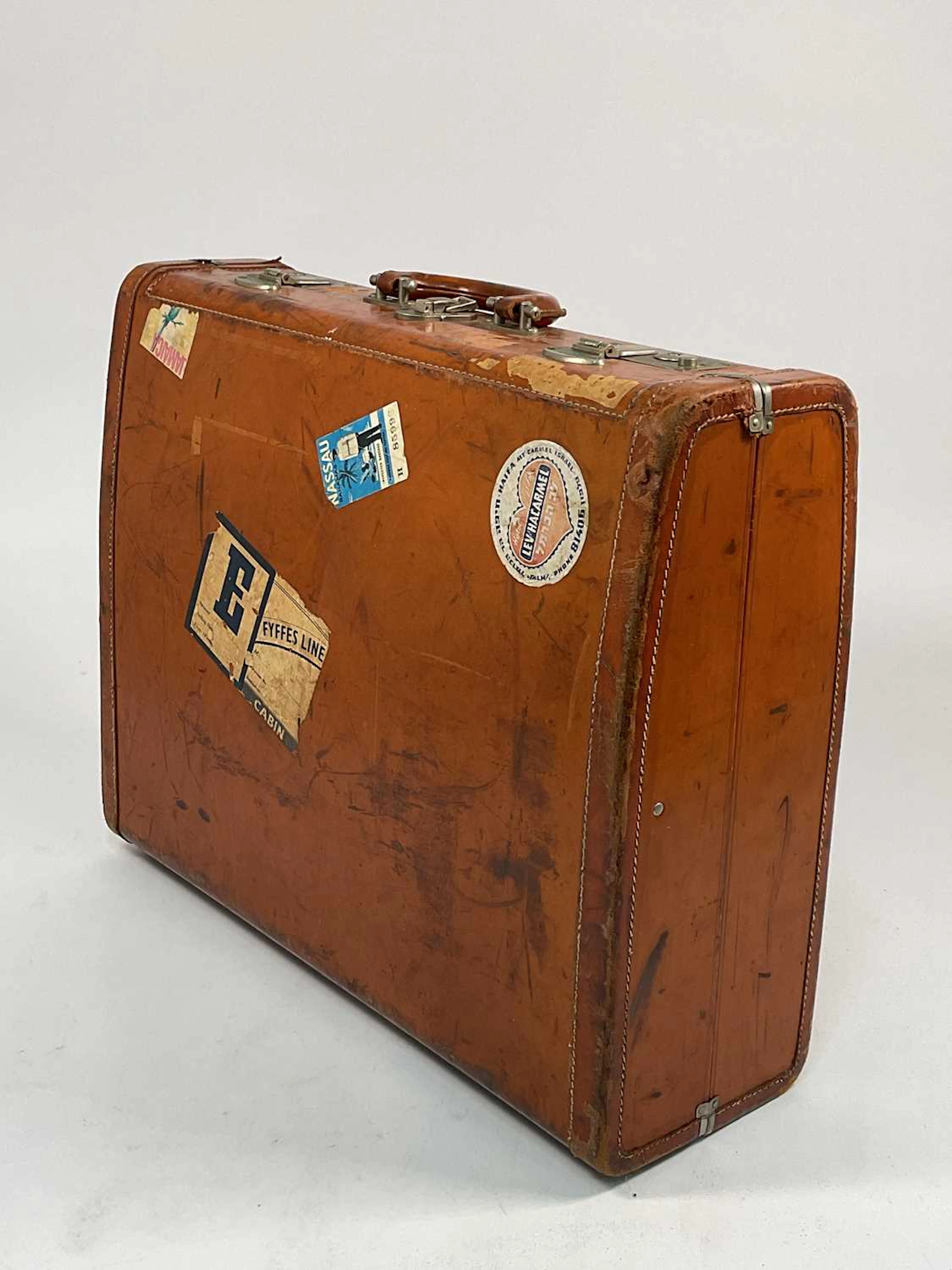 A vintage leather hard suitcase with numerous luggage...