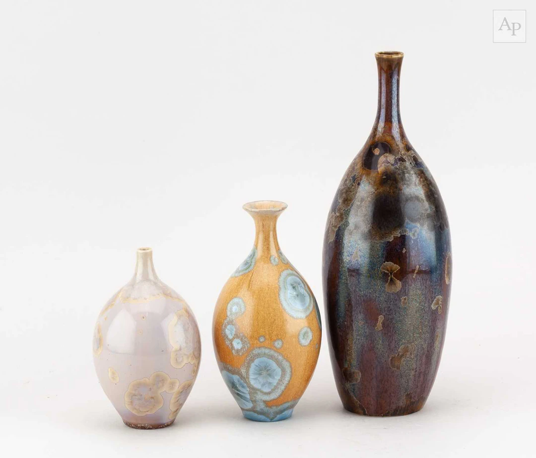 A graduated trio of porcelain bottles with narrow necks...