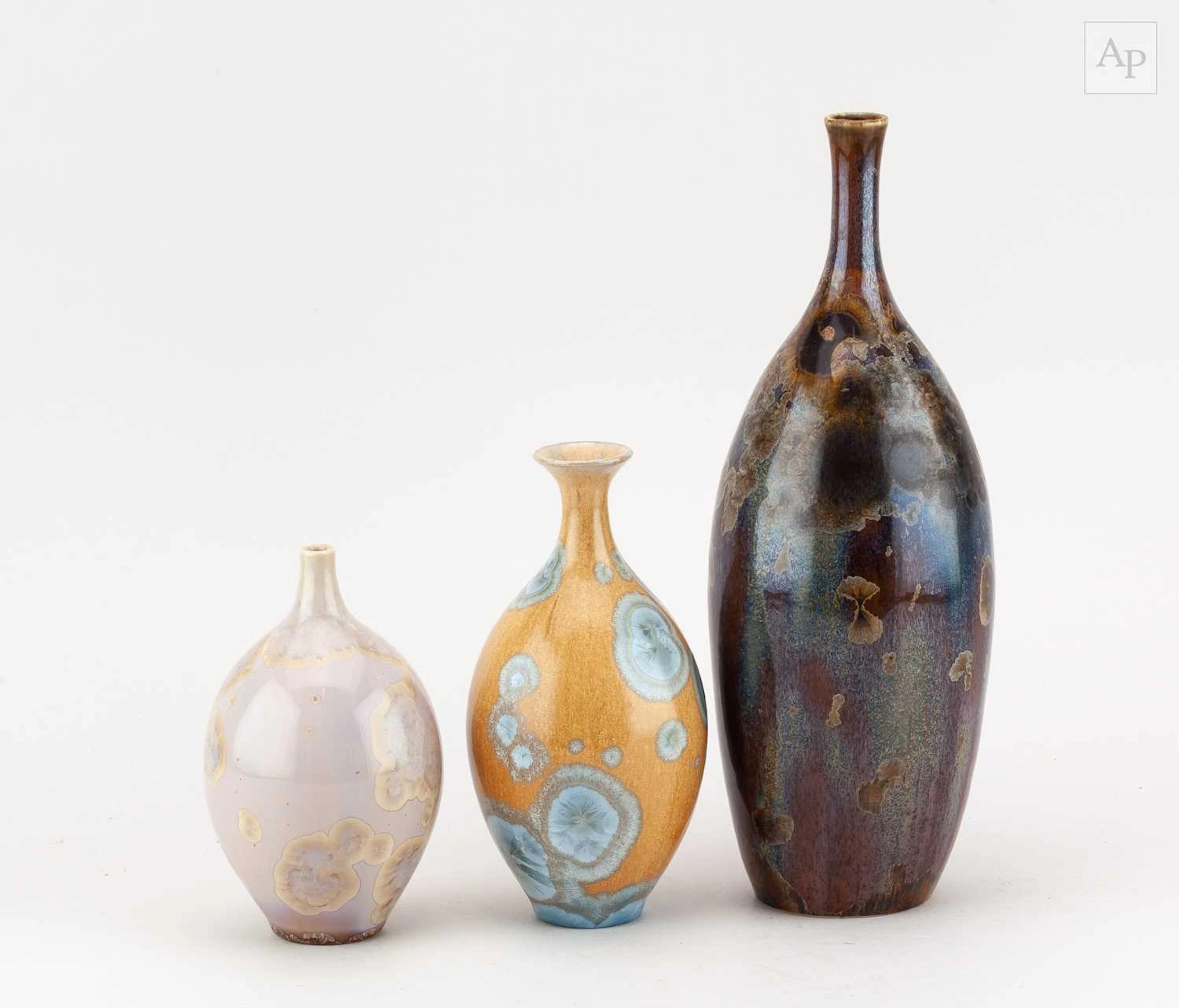 A graduated trio of porcelain bottles with narrow necks...