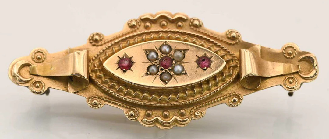 A Victorian 9ct yellow gold garnet and seed pearl set bar brooch