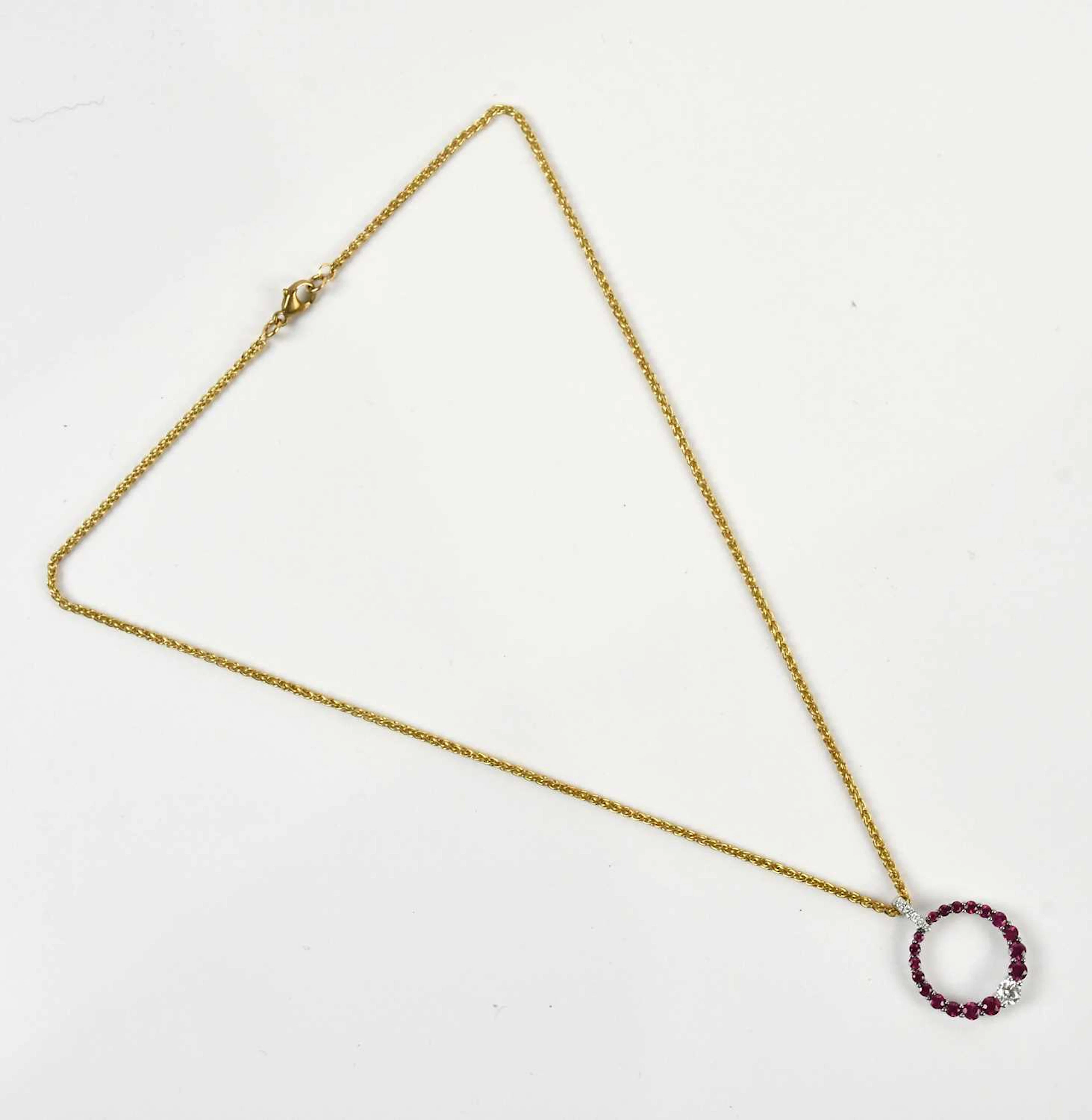 An 18ct white gold circular synthetic ruby and diamond pendant