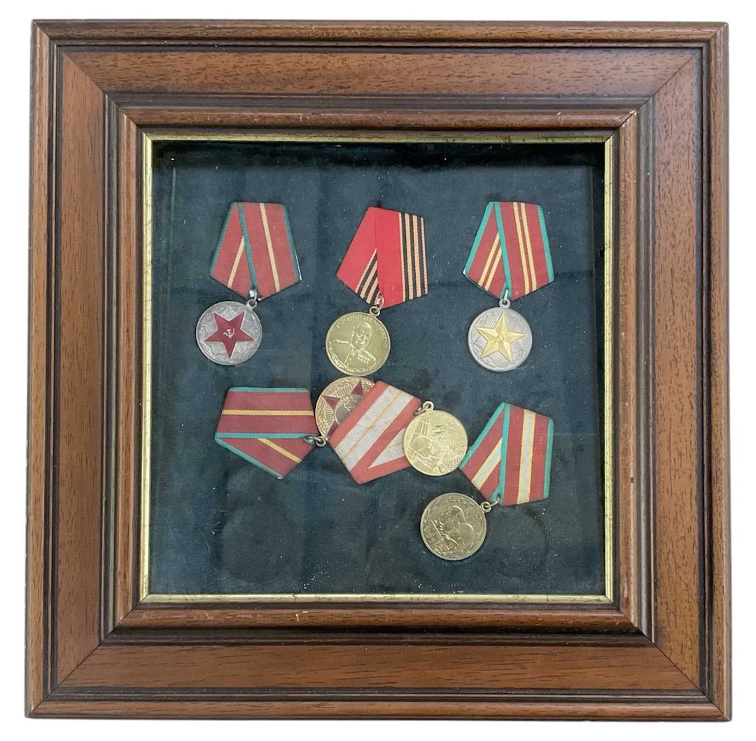 A framed montage of six Russian Soviet era military and commemorative medallions