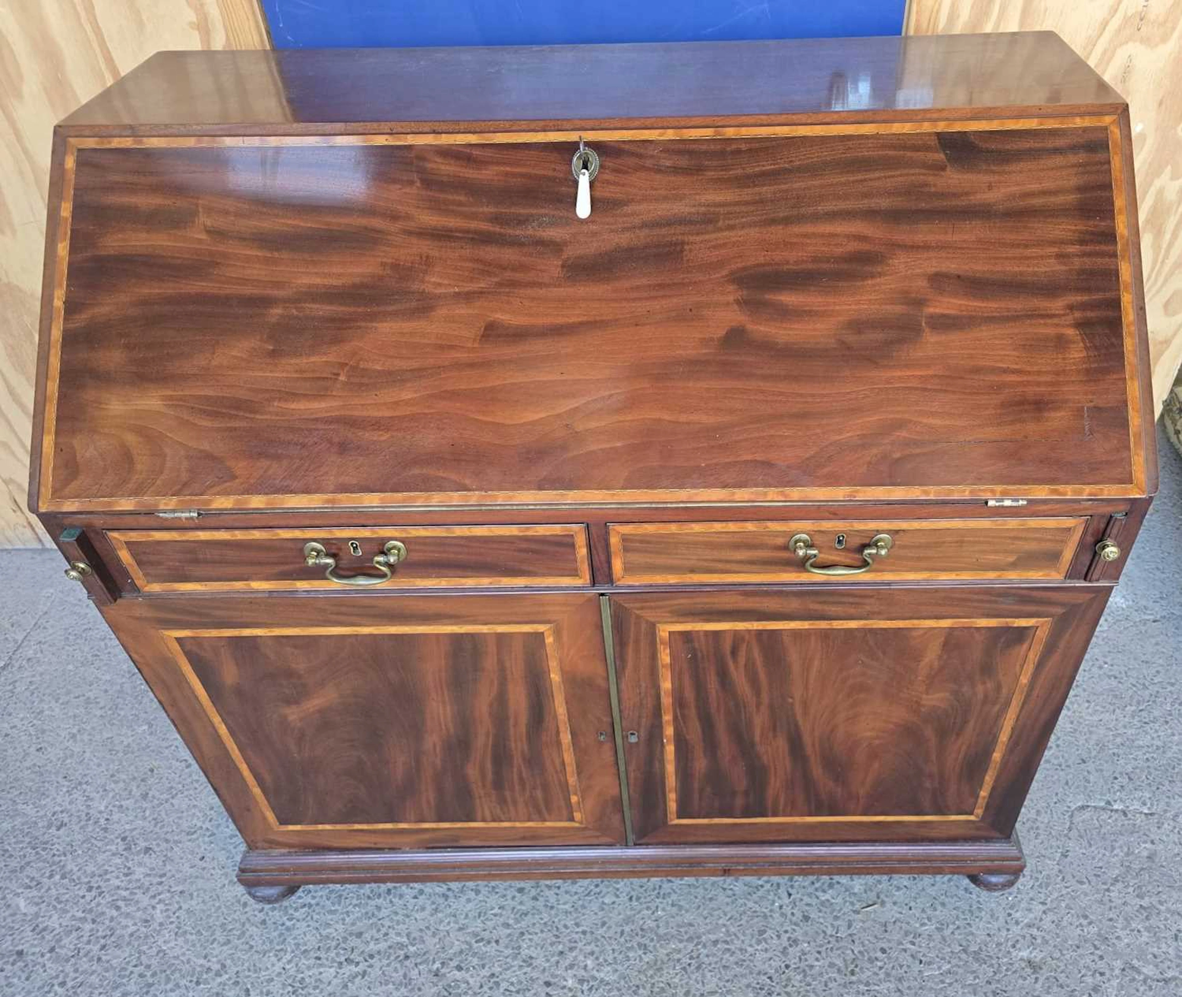 A 19th century mahogany drop-front bureau with fitted interior of shelves