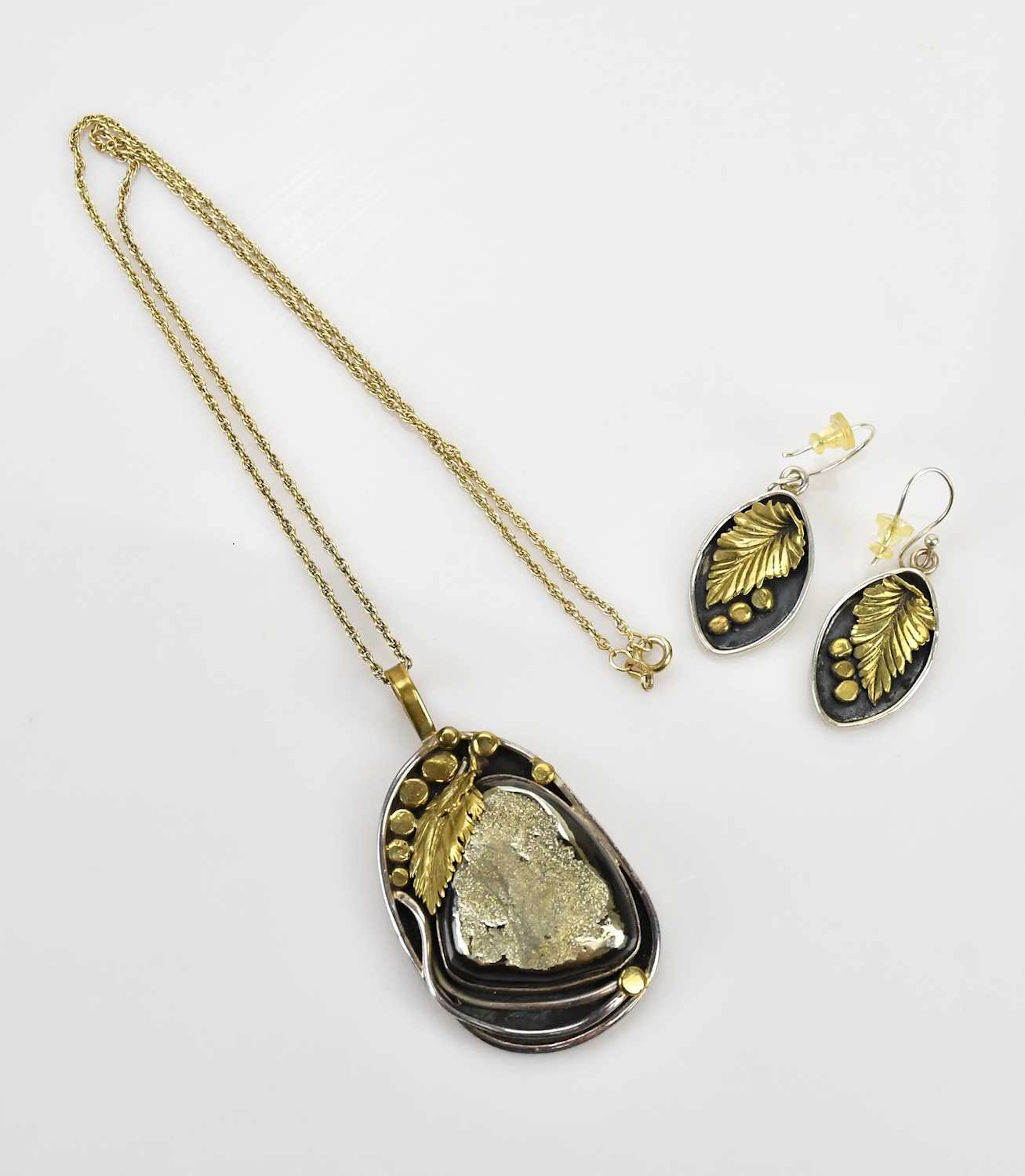 A Russian yellow and white sterling silver pyrite pendant with embossed leaf