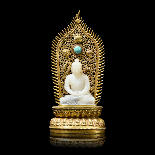 CHINESE WHITE JADE CARVING OF SHAKYAMUNI WITH GILT BRONZE STAND