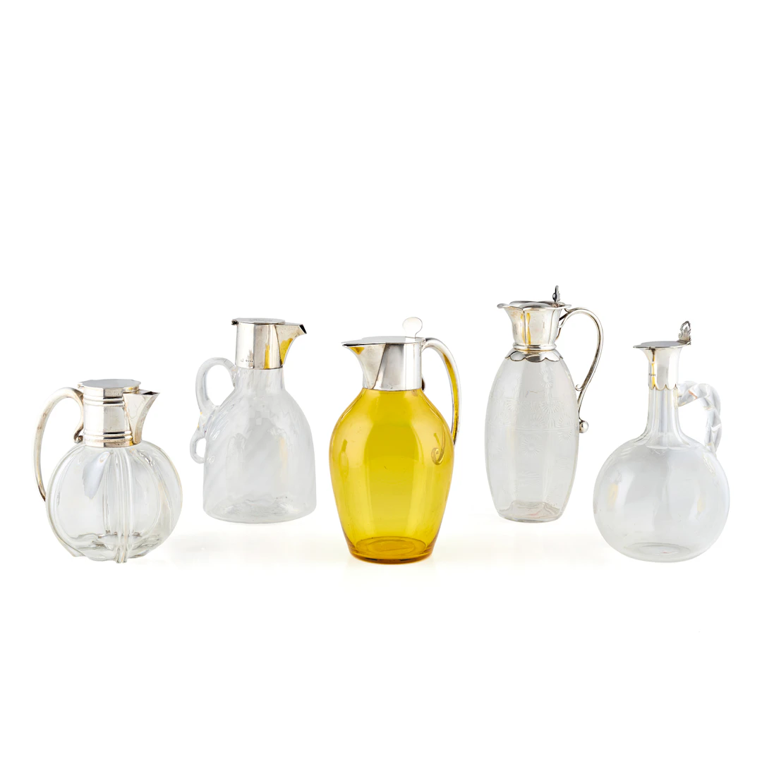 FIVE SILVER MOUNTED GLASS CLARET JUGS