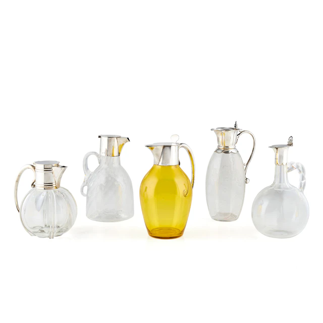 FIVE SILVER MOUNTED GLASS CLARET JUGS