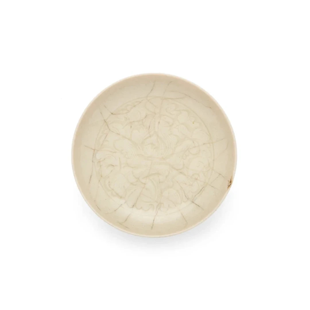 A small Chinese carved white-glazed dish 20th century...