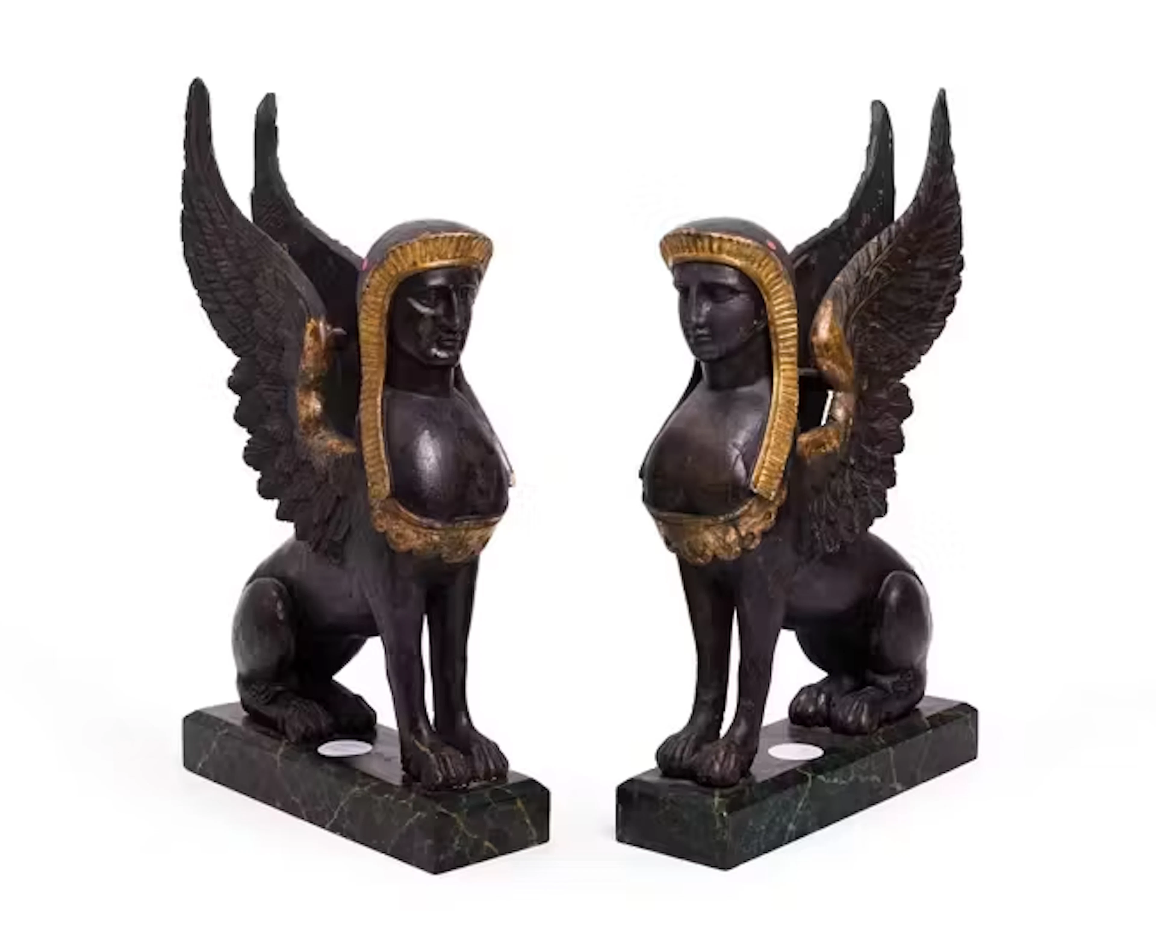 A pair of Regency ebonised and parcel-gilt models of sphinx
