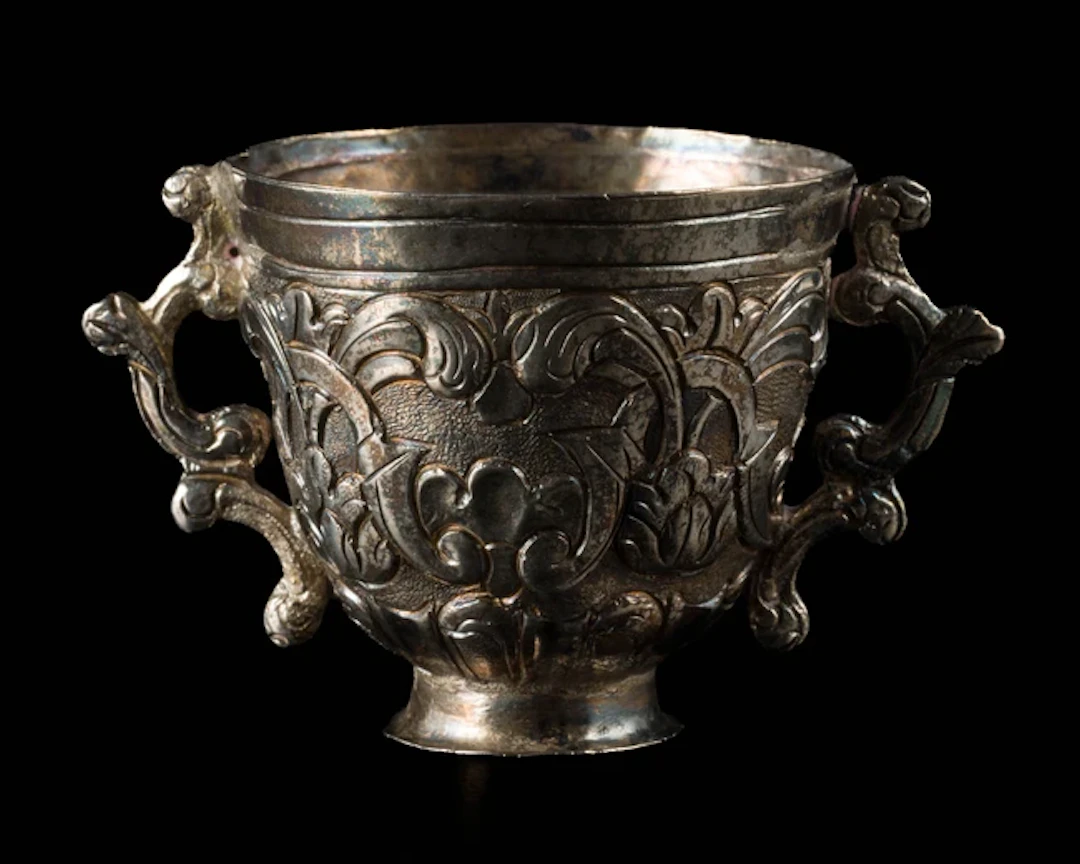 A small double-handled silver repousse work cup
