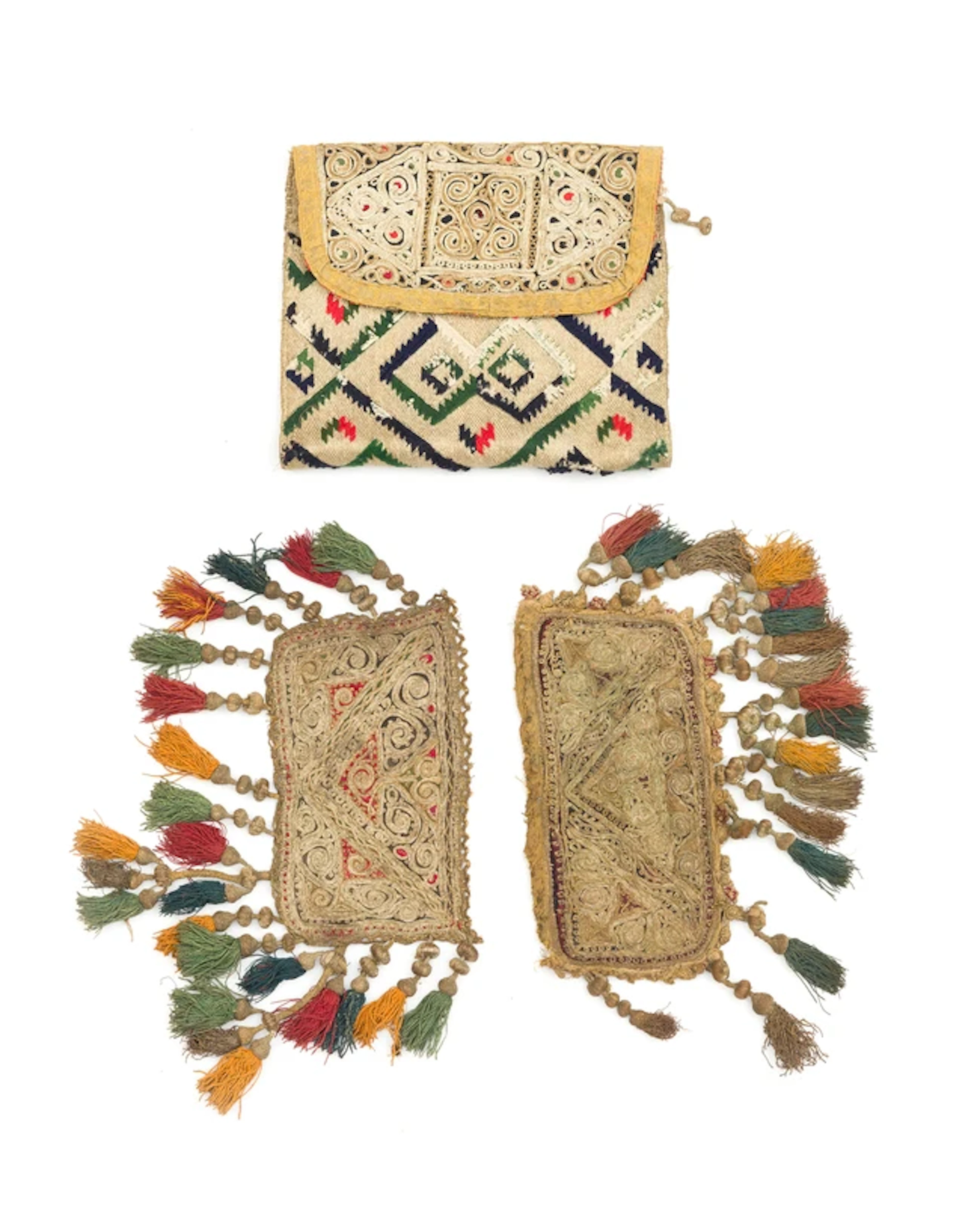 A silver thread and wool embroidered saddle bag and two flaps of another
