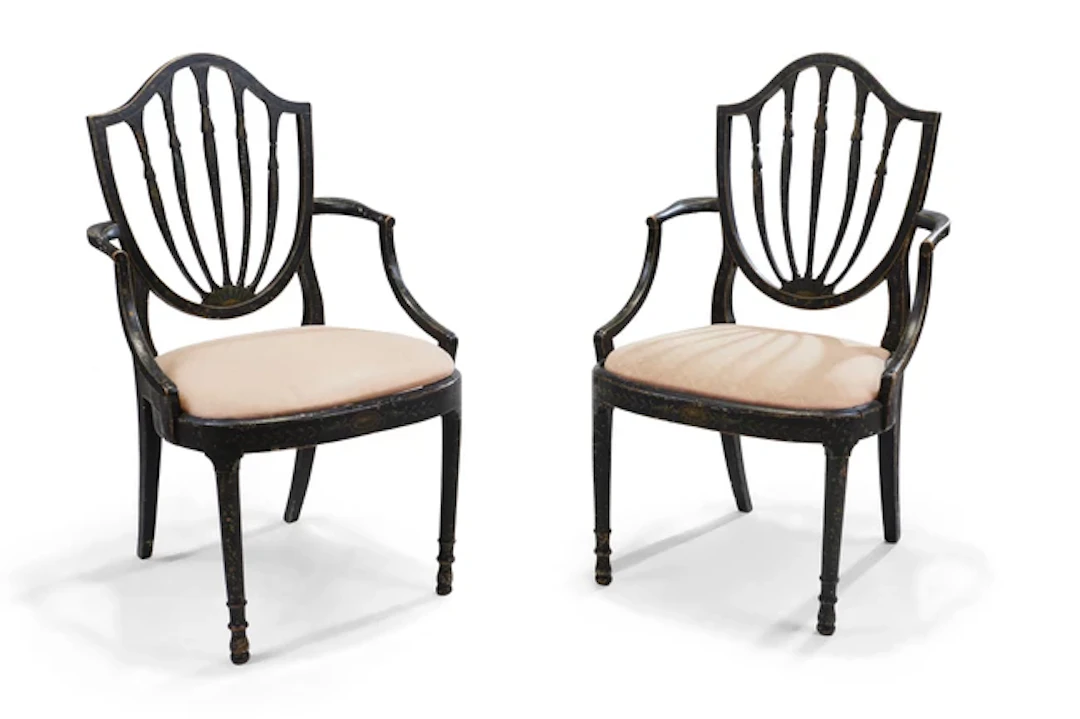 A pair of George III painted and ebonised open elbow chairs