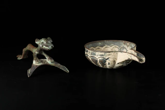 A bronze feline handle and a bronze gadrooned pouring vessel