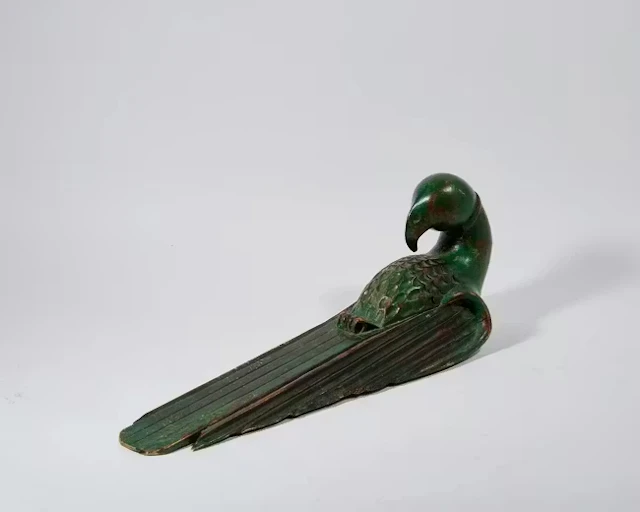A large carved wall-hanging sculpture of a macaw
