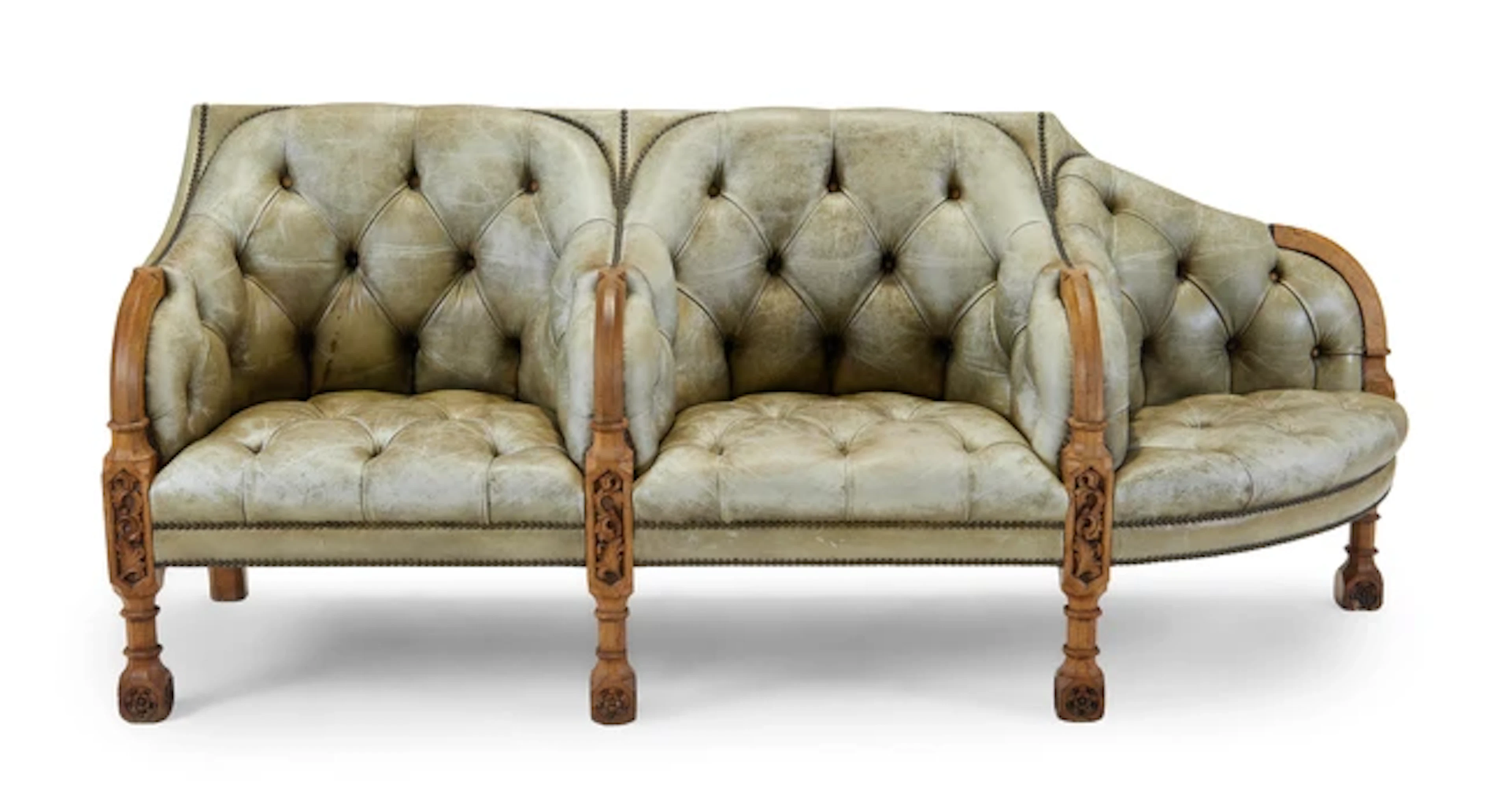 A Victorian Gothic Revival carved oak conversation sofa