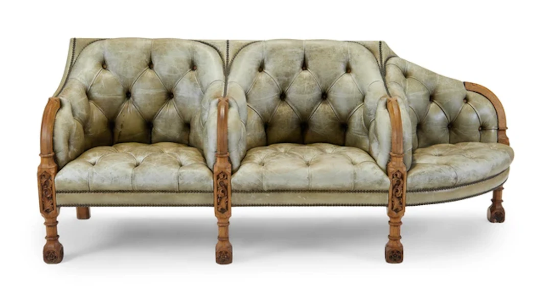 A Victorian Gothic Revival carved oak conversation sofa