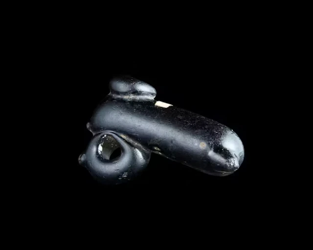 A Roman black glass miniature phallic oil lamp...