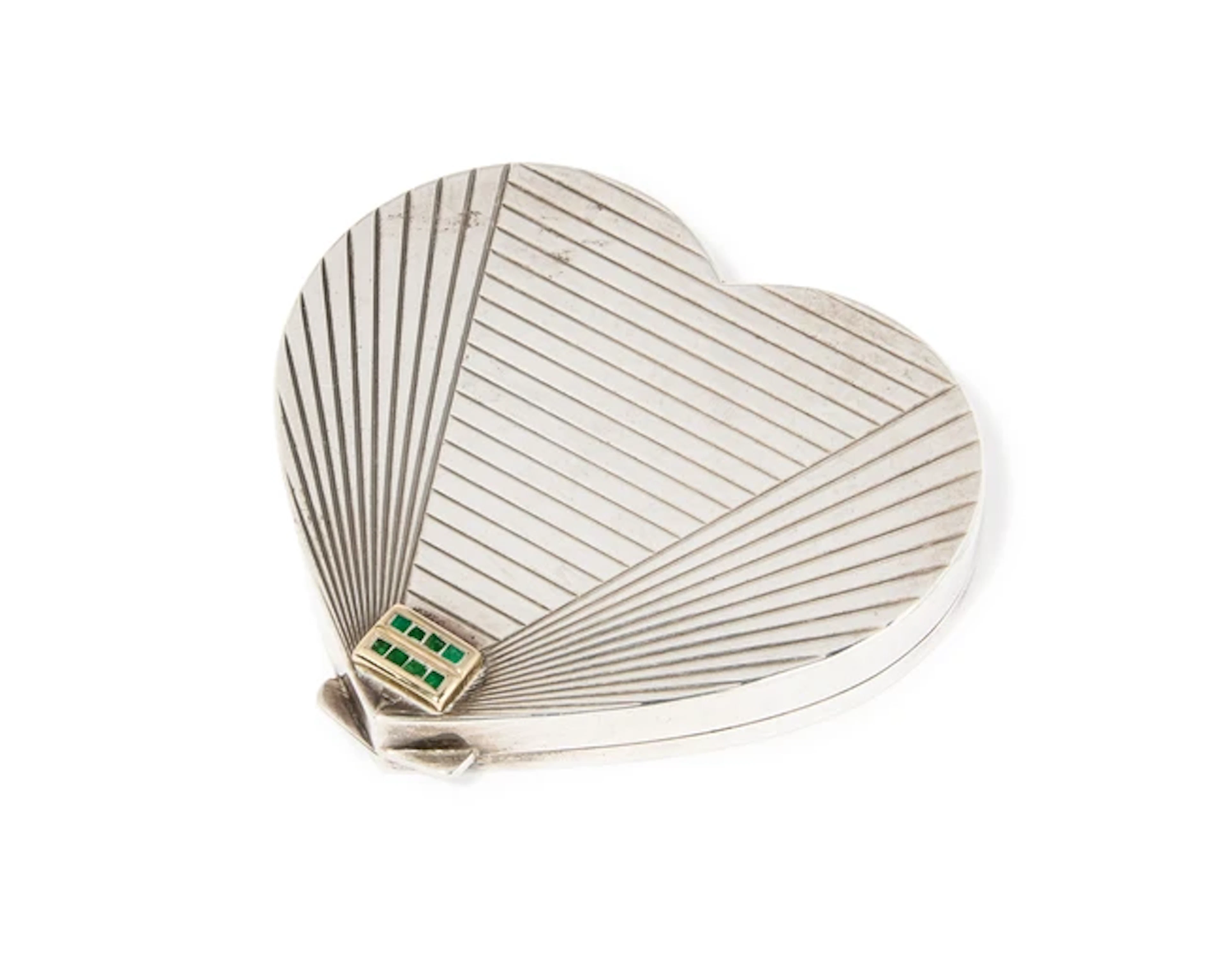 An Art Deco silver compact with emerald thumbpiece