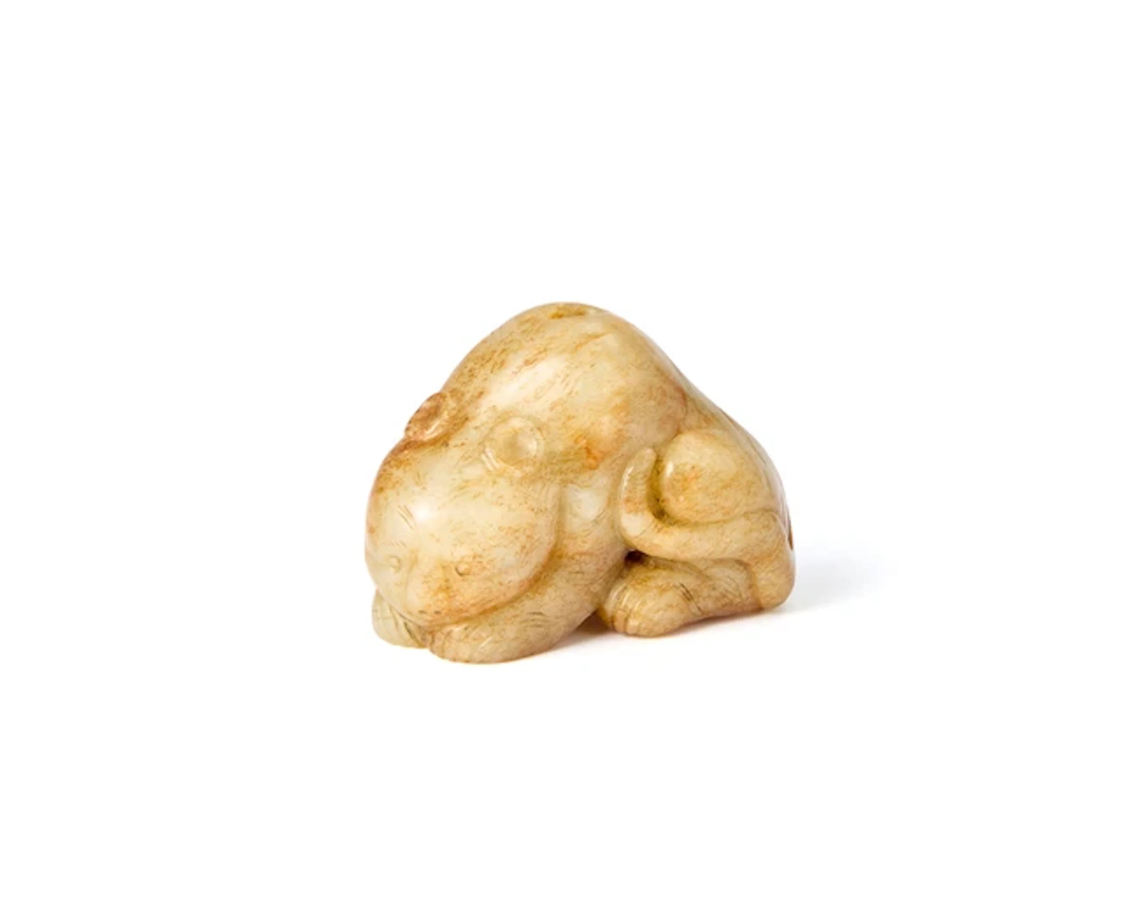 A Chinese celadon green and russet jade carving of a tiger Ming dynasty