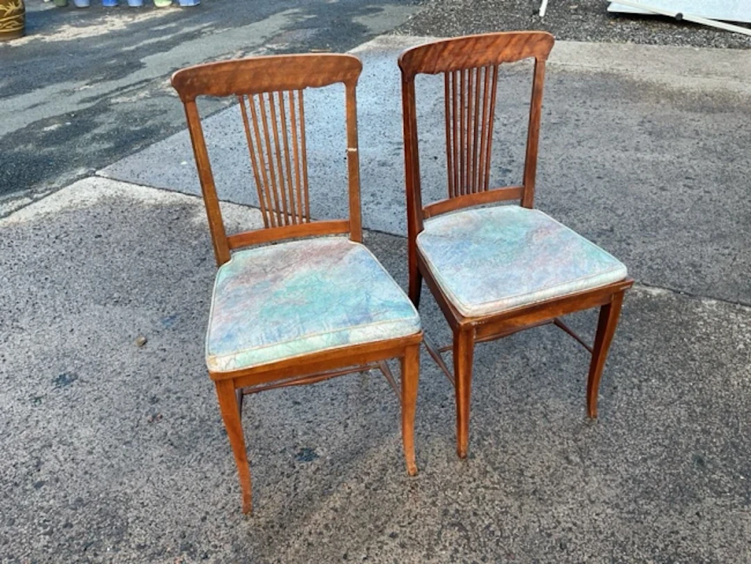 A pair of stained chairs with spindle backs above tapering cane seats