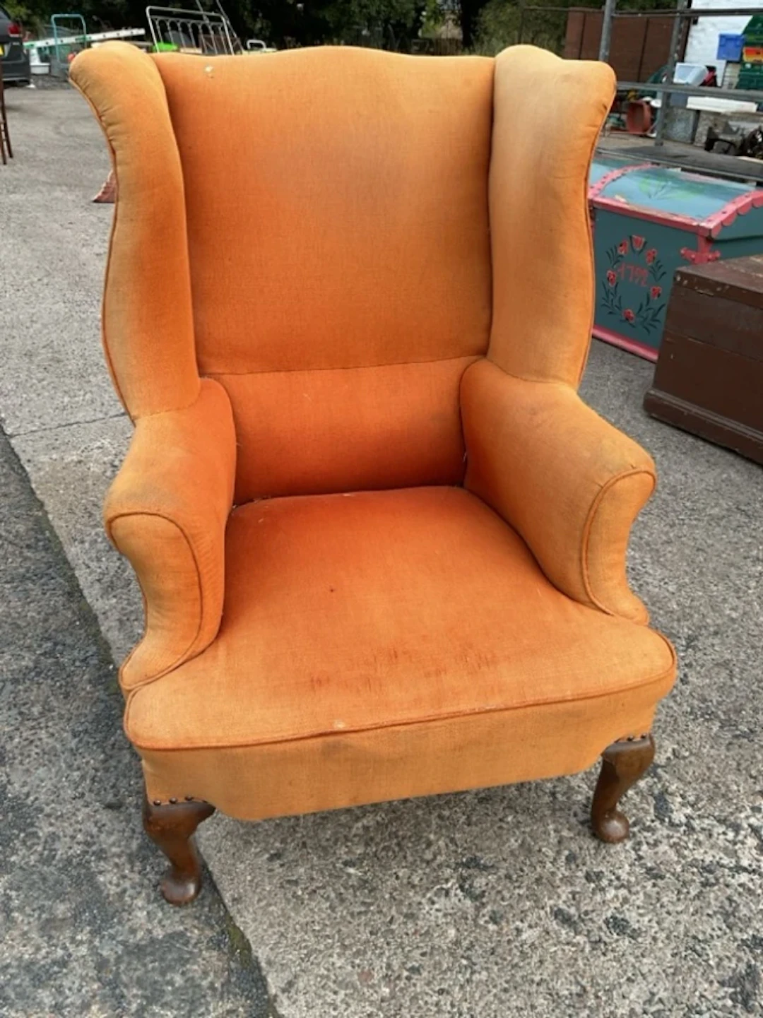 A Georgian style wing armchair with padded back and outscrolled arms