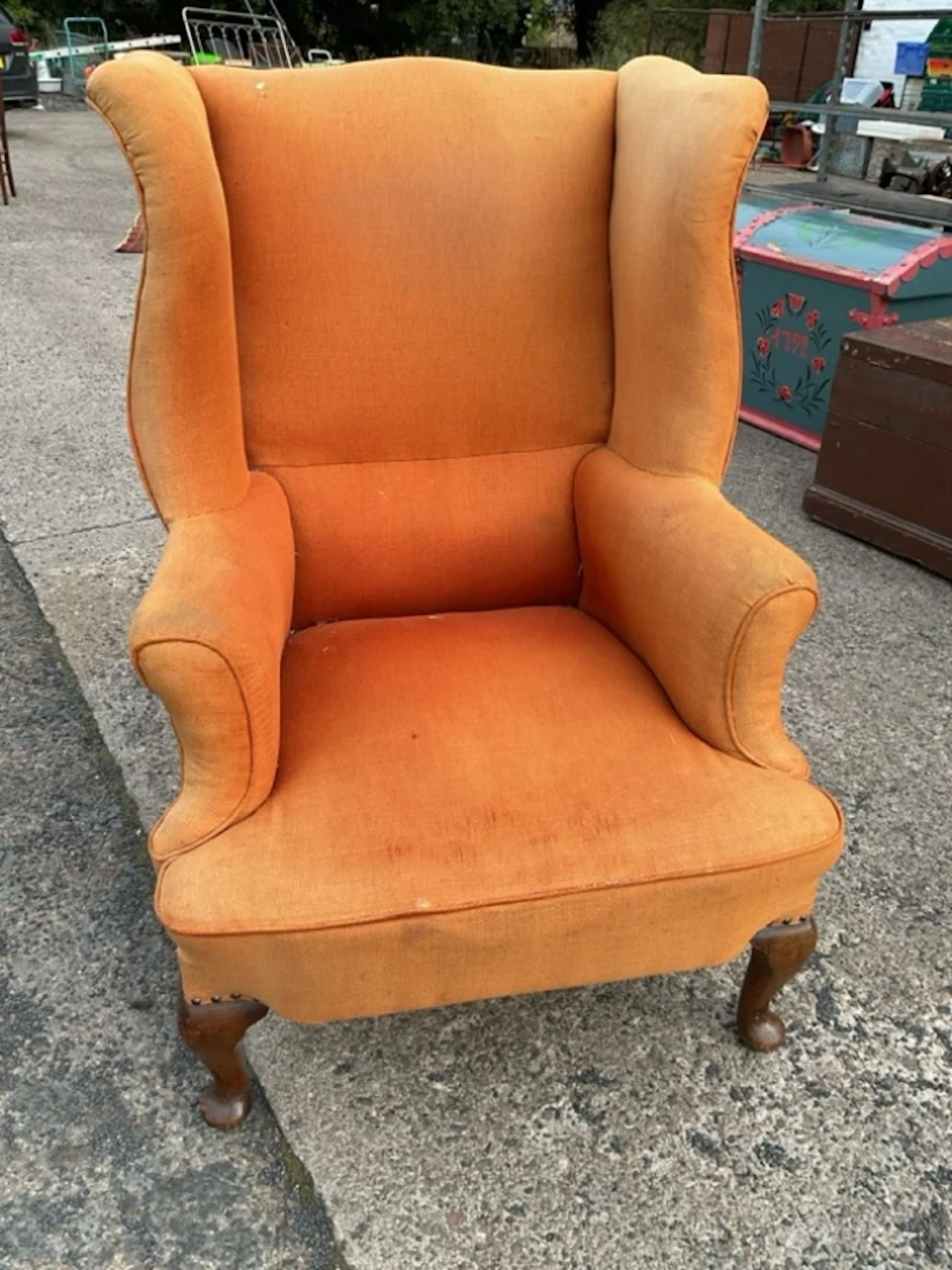 A Georgian style wing armchair with padded back and outscrolled arms