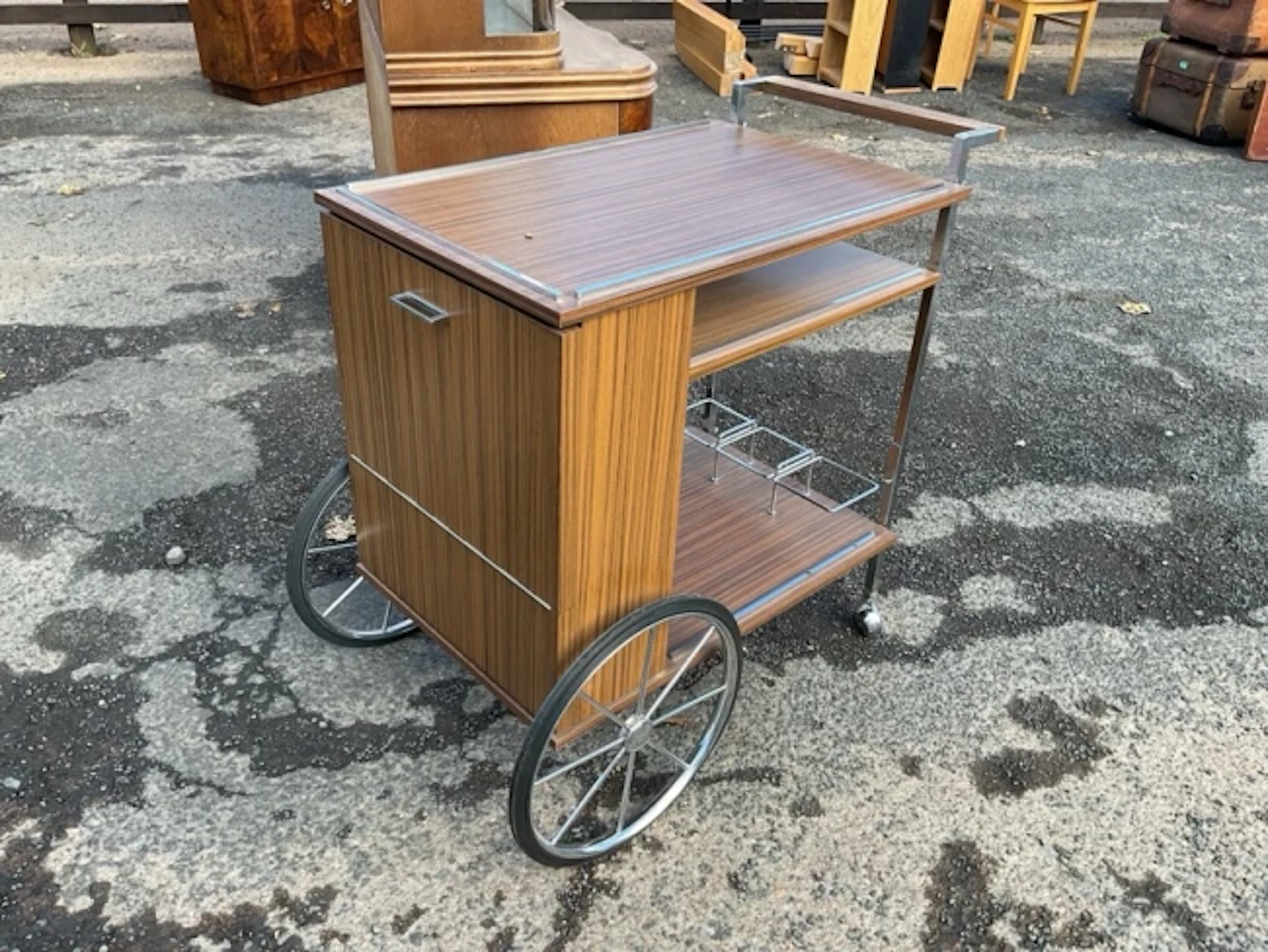 A 70s dinner wagon in faux walnut, the chromed square section frame