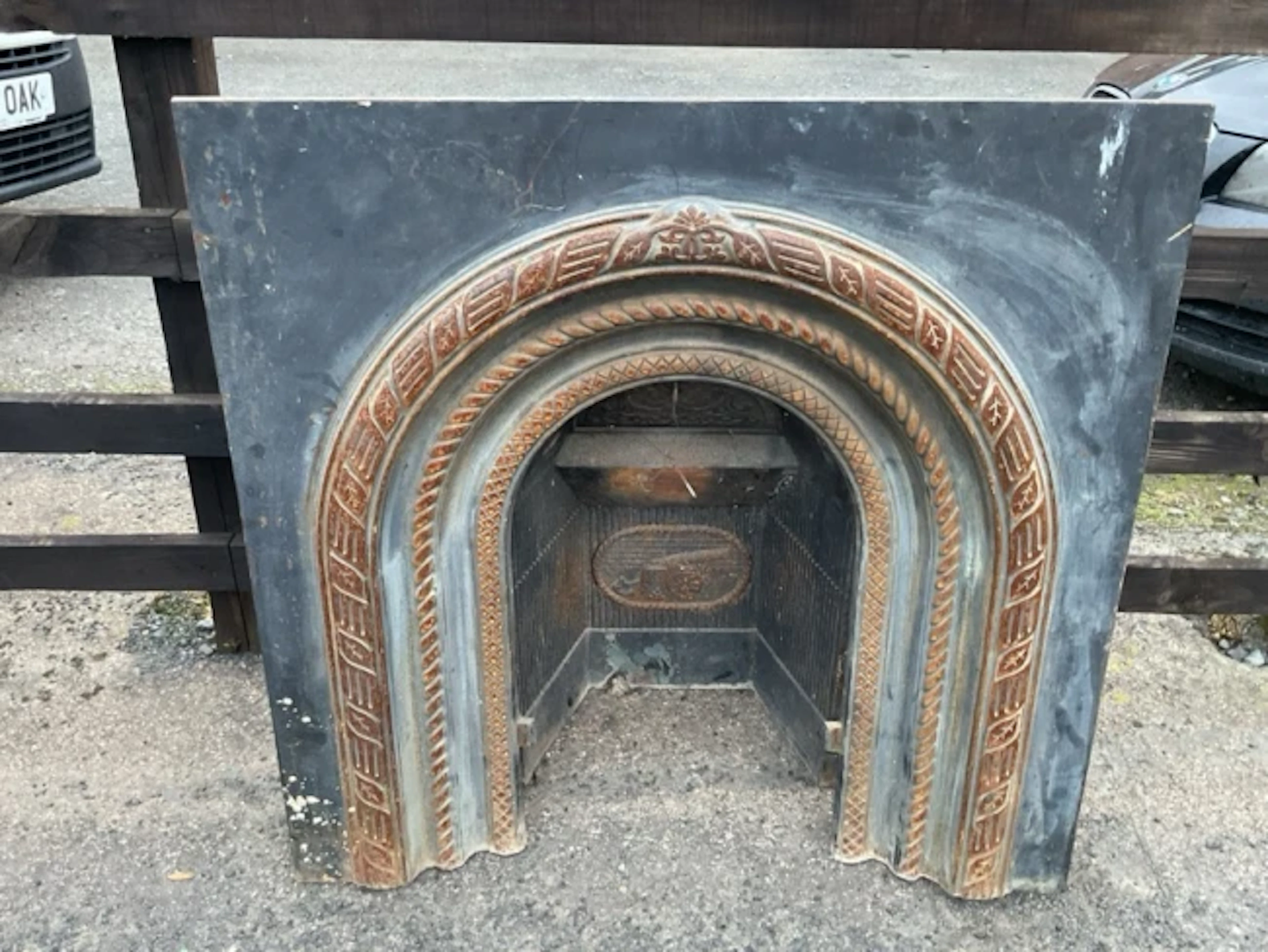 A Victorian cast iron fire insert with arched ribbon moulded & twisted