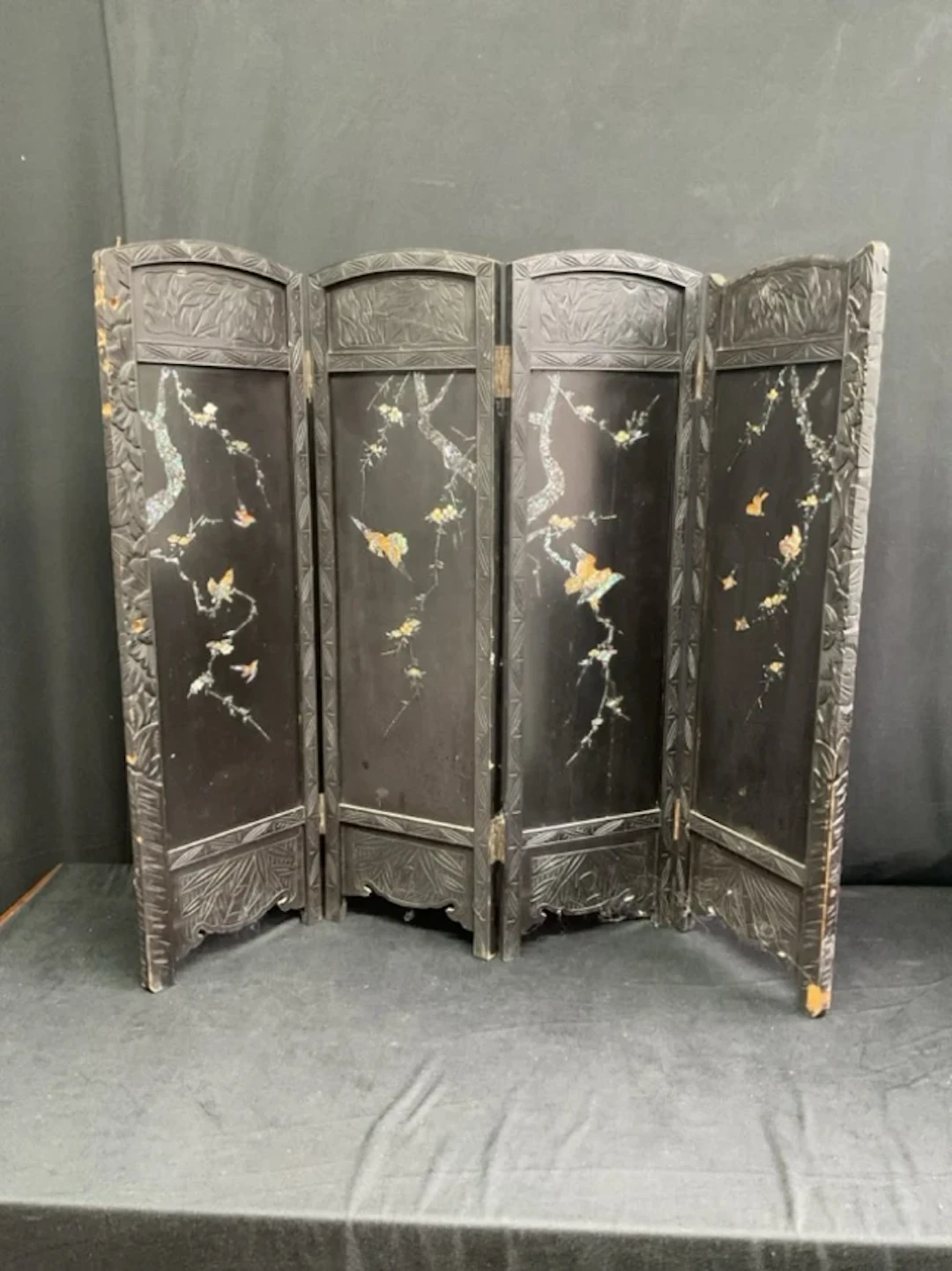 A C19th four-fold Japanese lacquer fire screen the arched ebonised