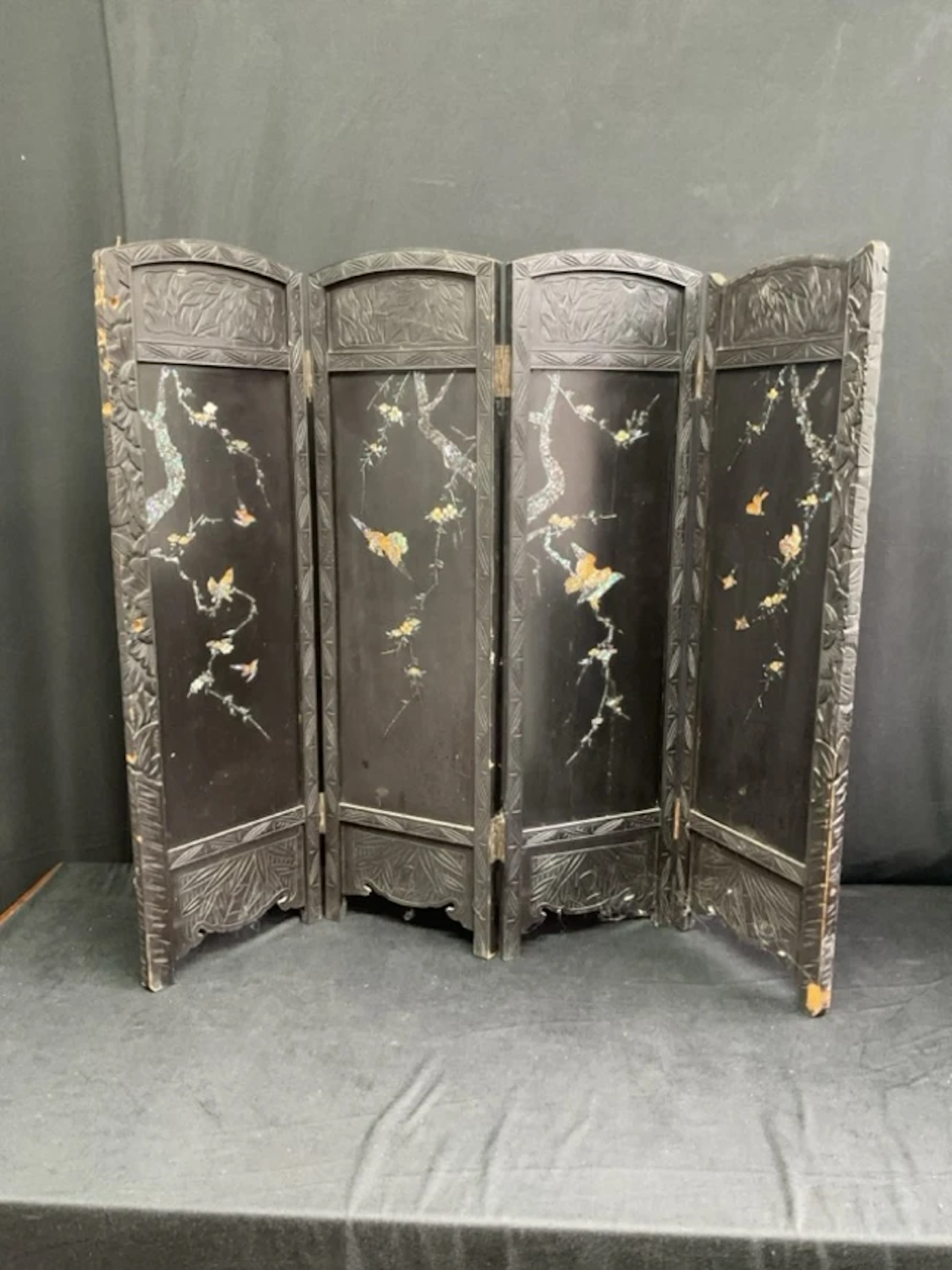 A C19th four-fold Japanese lacquer fire screen the arched ebonised