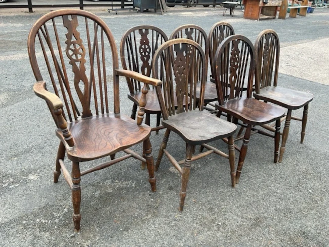 A set of seven Edwardian wheelback chairs including a carver, the