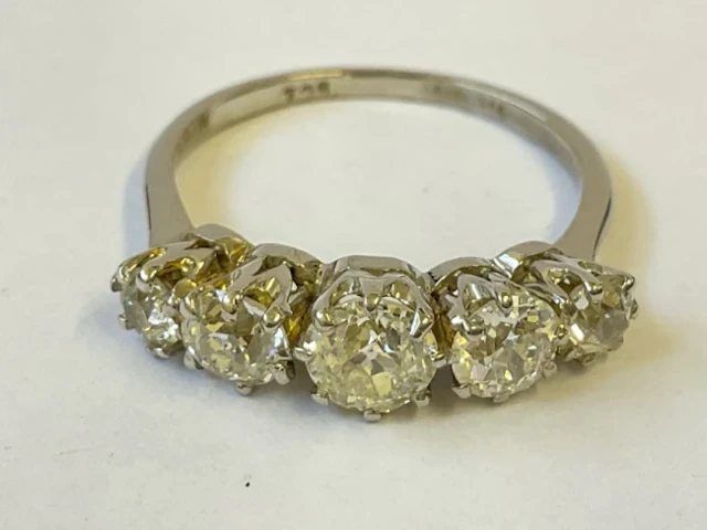 An 18ct white gold ring claw set with five diamonds totalling approx