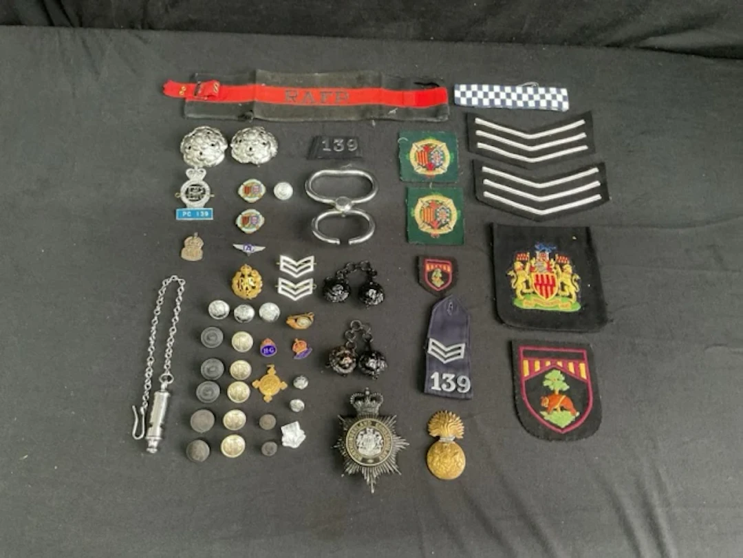 A collection of police, military, and civil buttons, badges and insignia