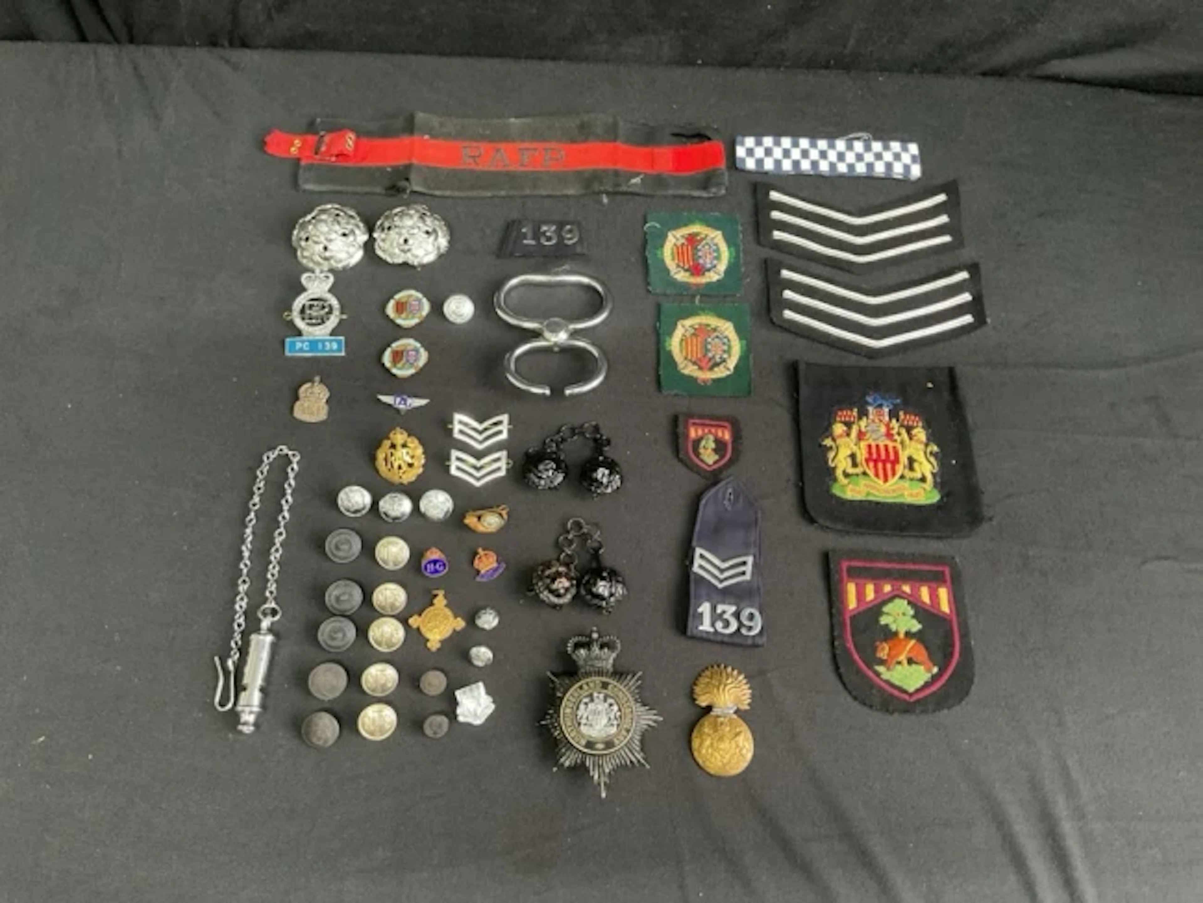 A collection of police, military, and civil buttons, badges and insignia
