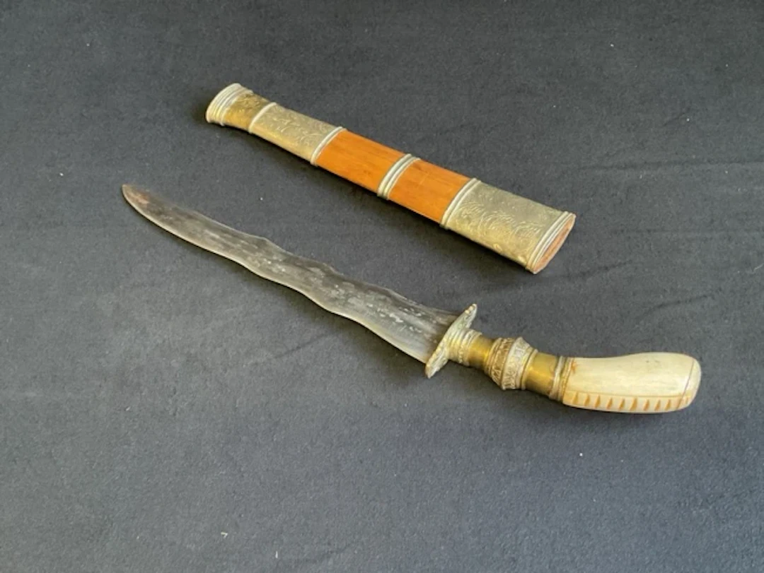 A Philippine Gunong dagger with bone & brass handle and tapered wavy-edged