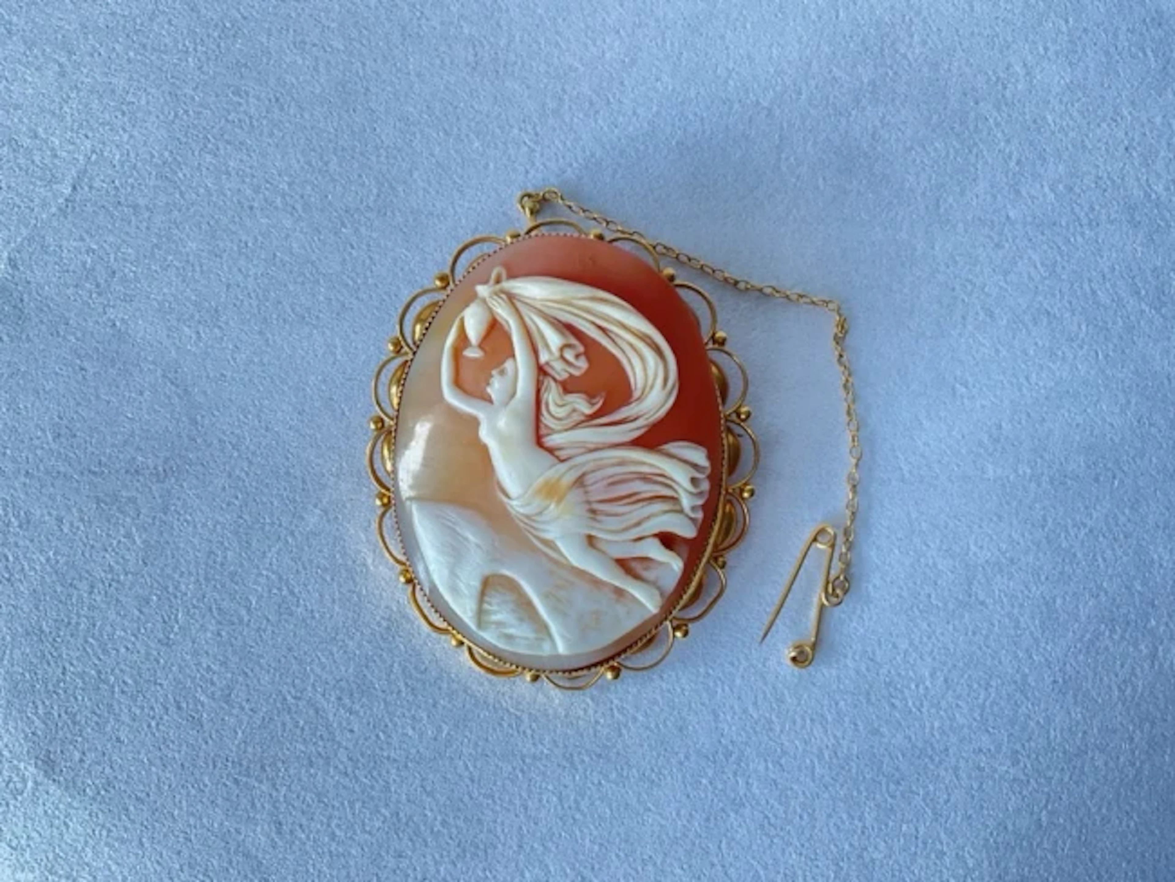 A 9ct gold shell cameo brooch having scene depicting Iris carrying