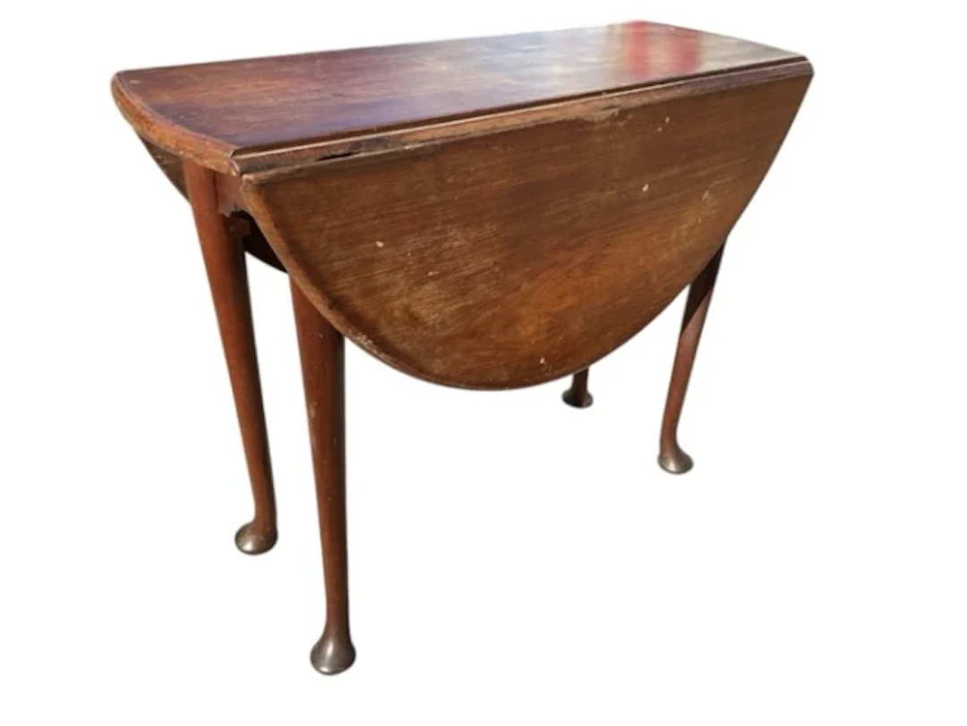 An oval Georgian mahogany dining table with two rule-jointed drop-leaves